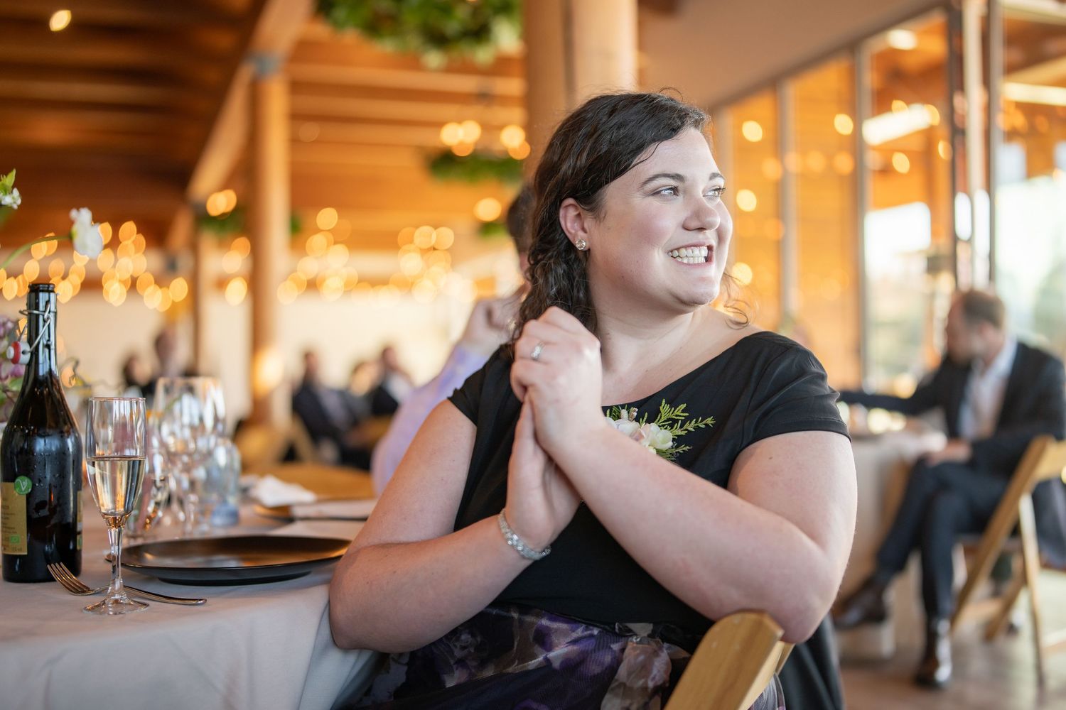 Guest smiles warmly while seated at an elegant dining table during a celebration.