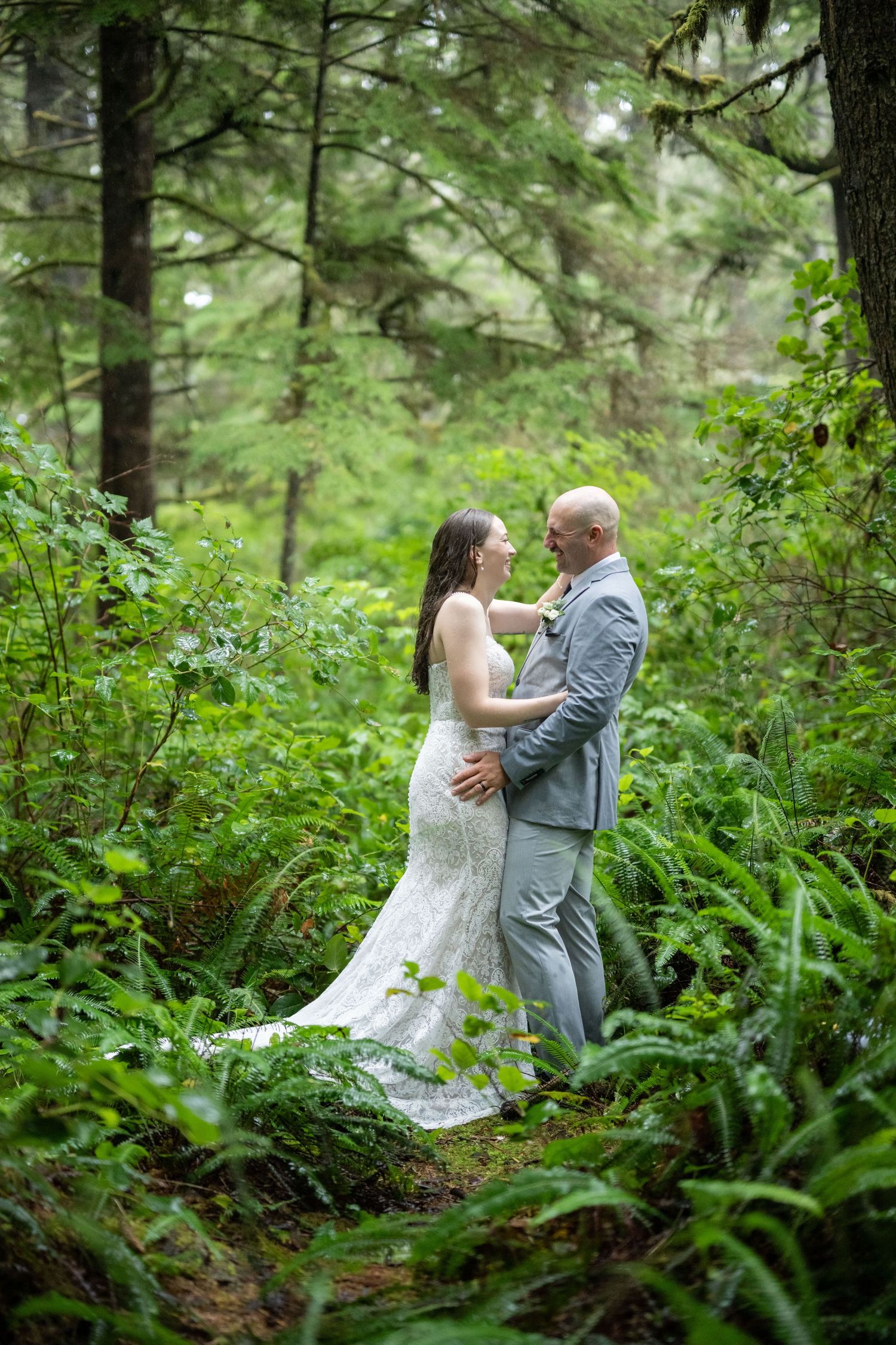 A couple shares their first dance surrounded by ferns in a magical forest setting.