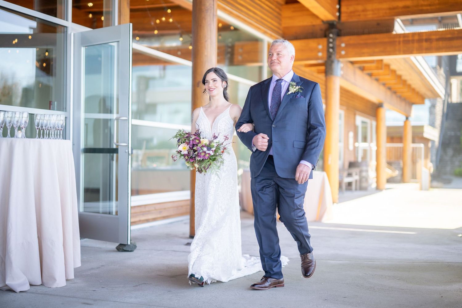 Wedding party walking through a modern lodge venue with wooden architecture.