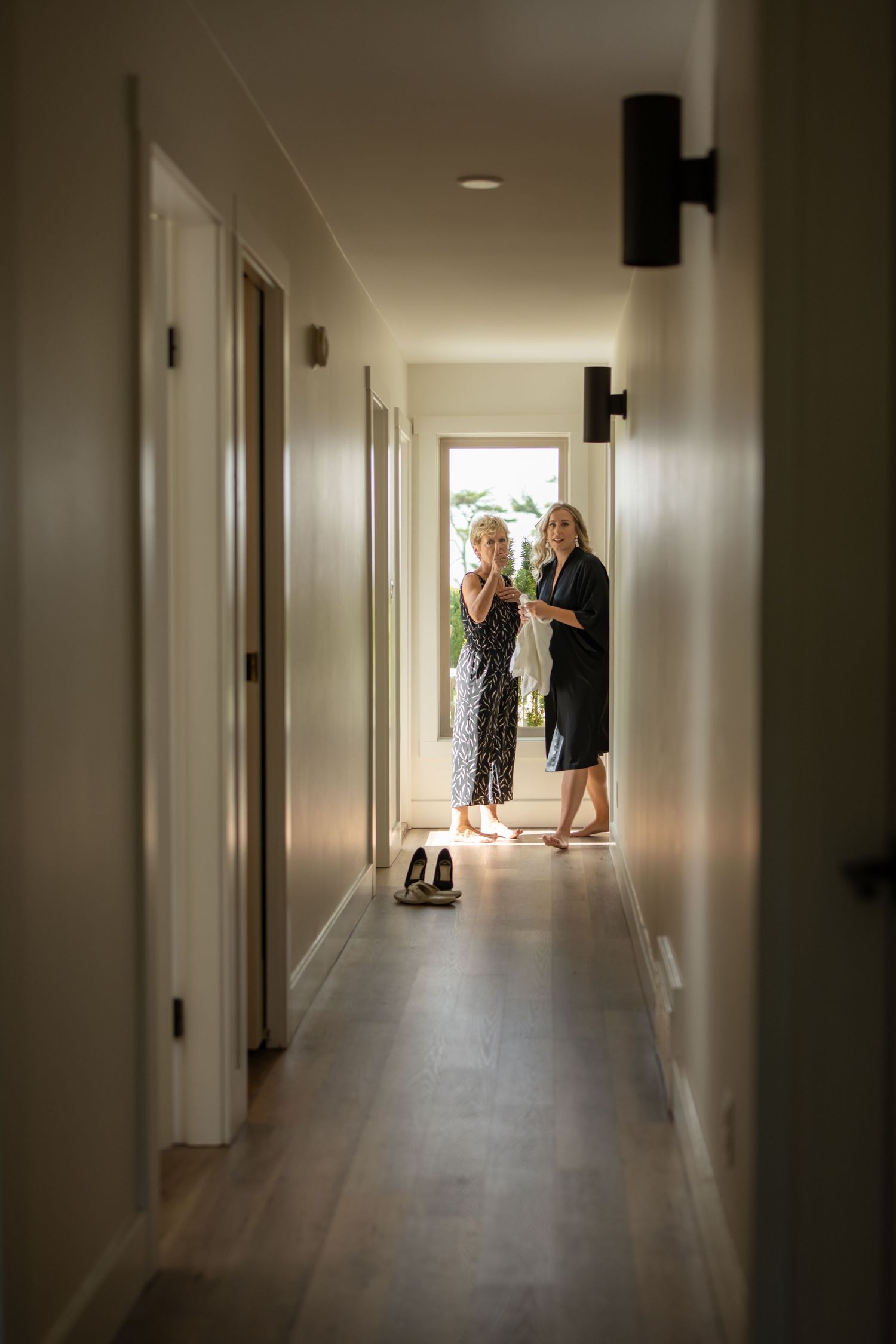 Long white hallway with natural light streaming in from windows at the end.