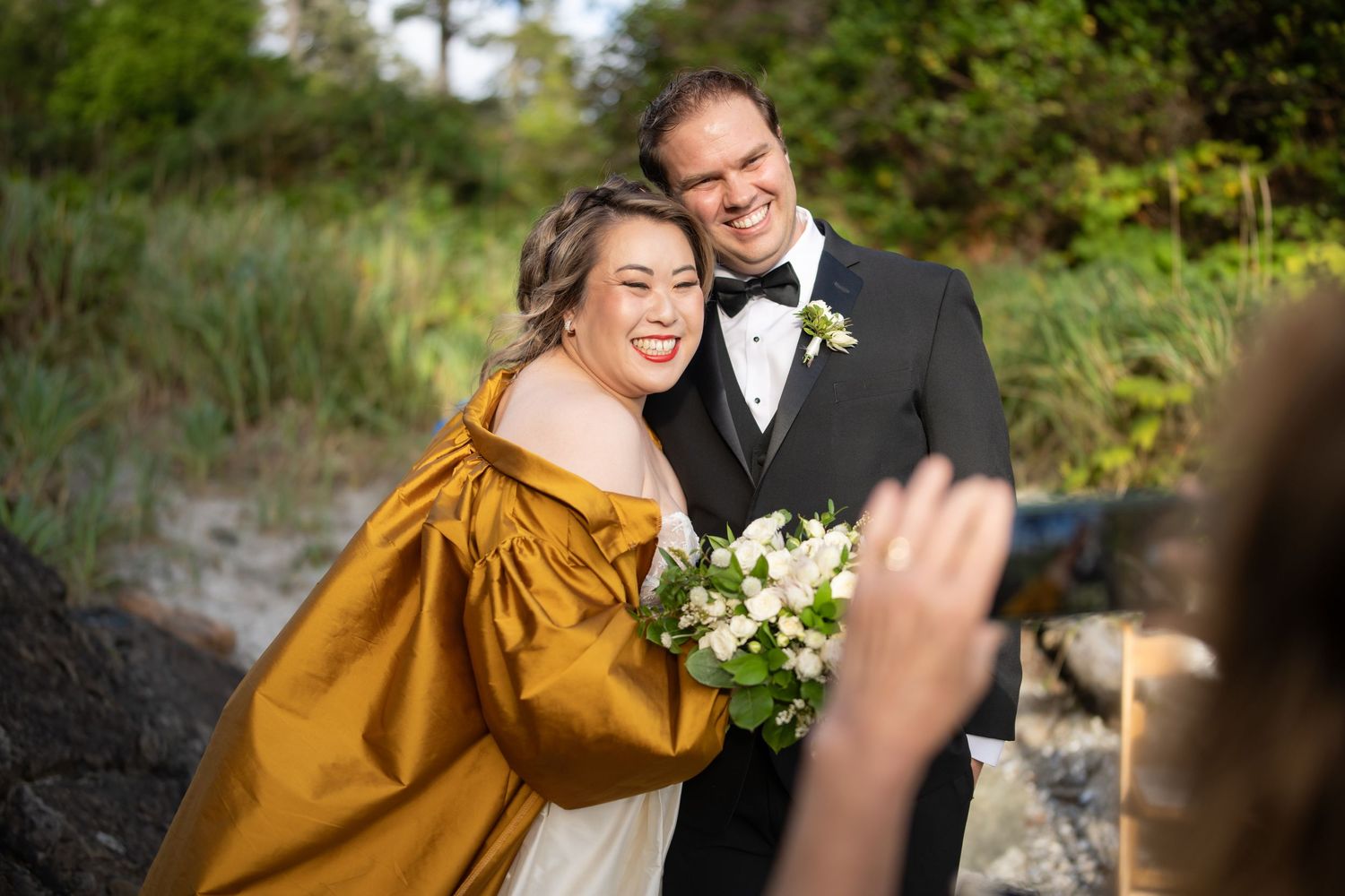 A wedding celebration moment captured in a scenic forest setting with white flowers.