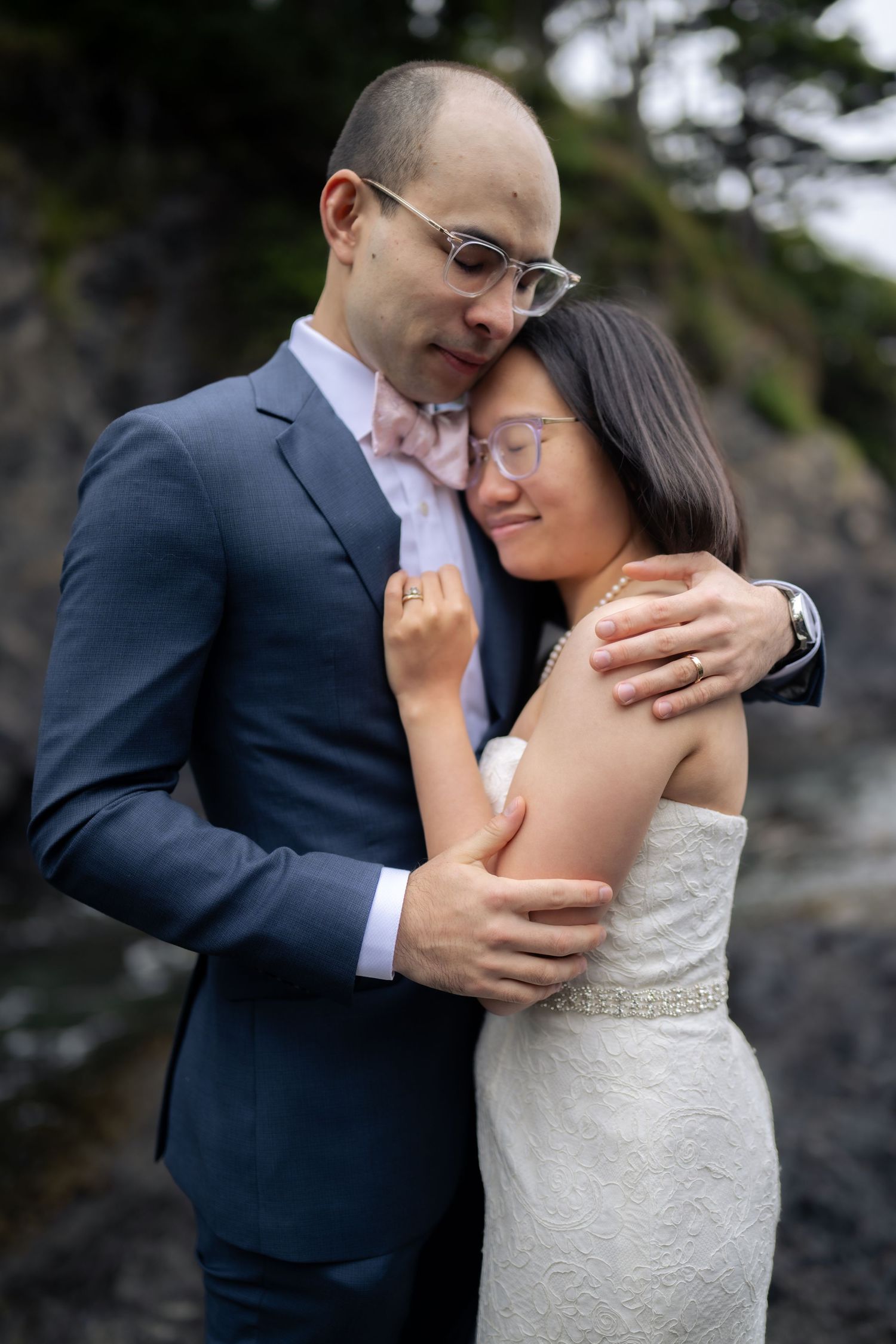 Tender embrace captured in intimate wedding portraits by the sea.