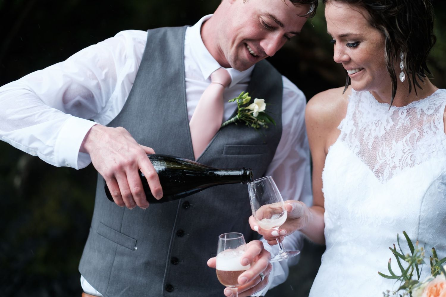 A couple shares a toast with champagne glasses during an intimate wedding celebration.
