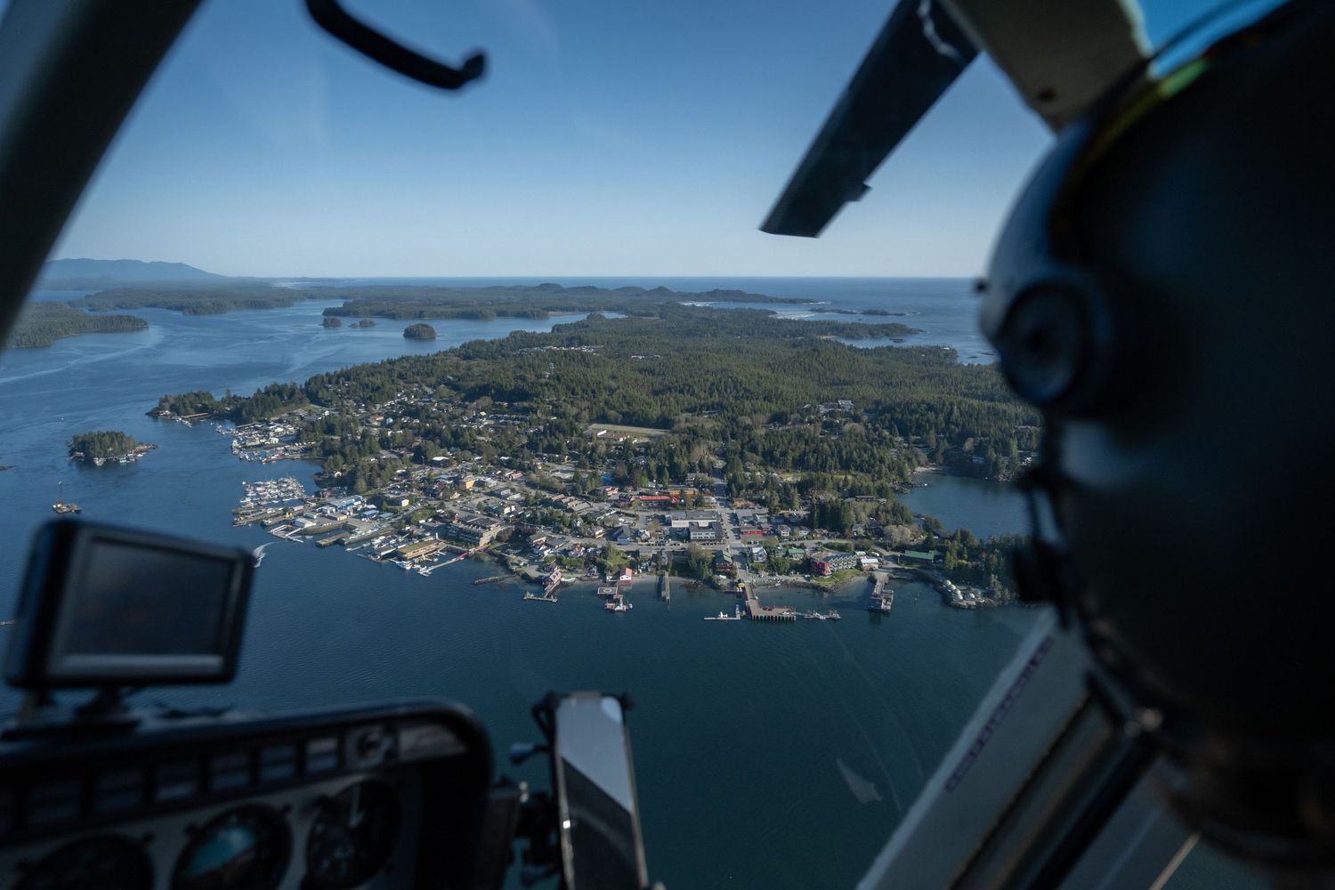 Aerial view of coastal town and waterways from helicopter cockpit.