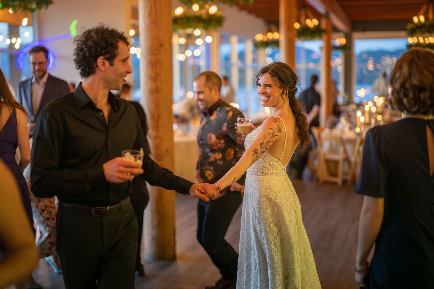 Couples dancing together at an elegant indoor wedding reception with warm lighting.