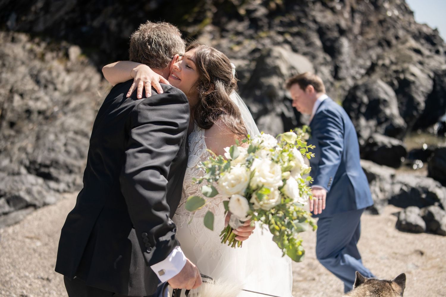 Intimate wedding ceremony taking place on rocky coastal cliffs.
