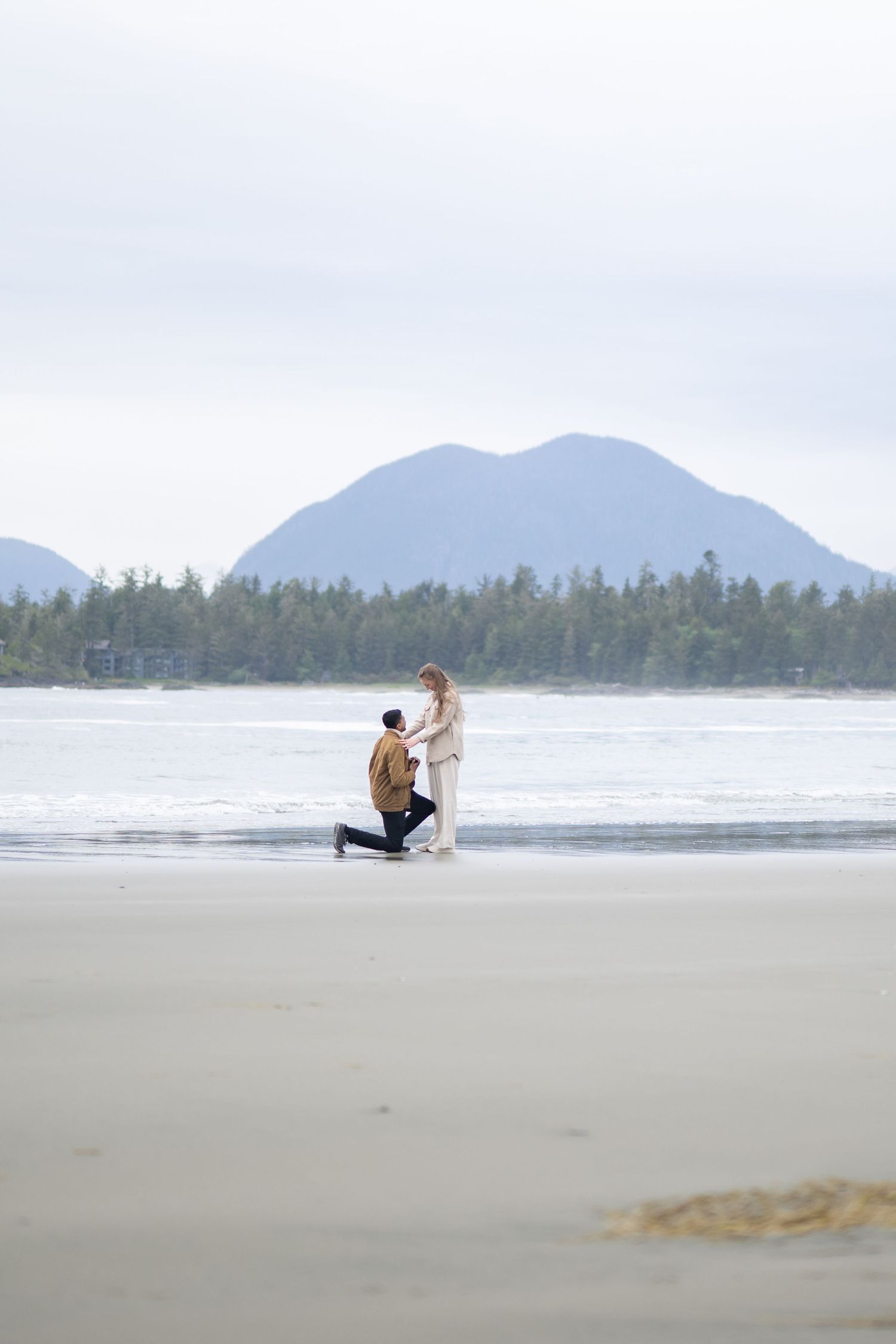 Special moment captured on a remote beach with mountain backdrop.