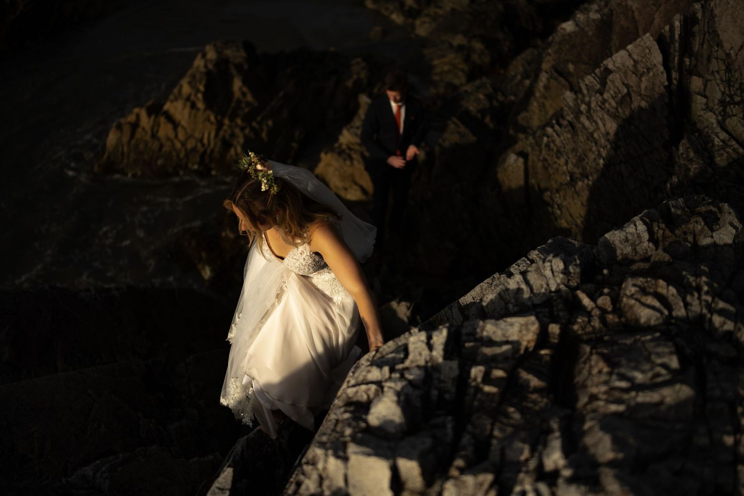 Dramatic lighting on rocky coastal cliffs at sunset.