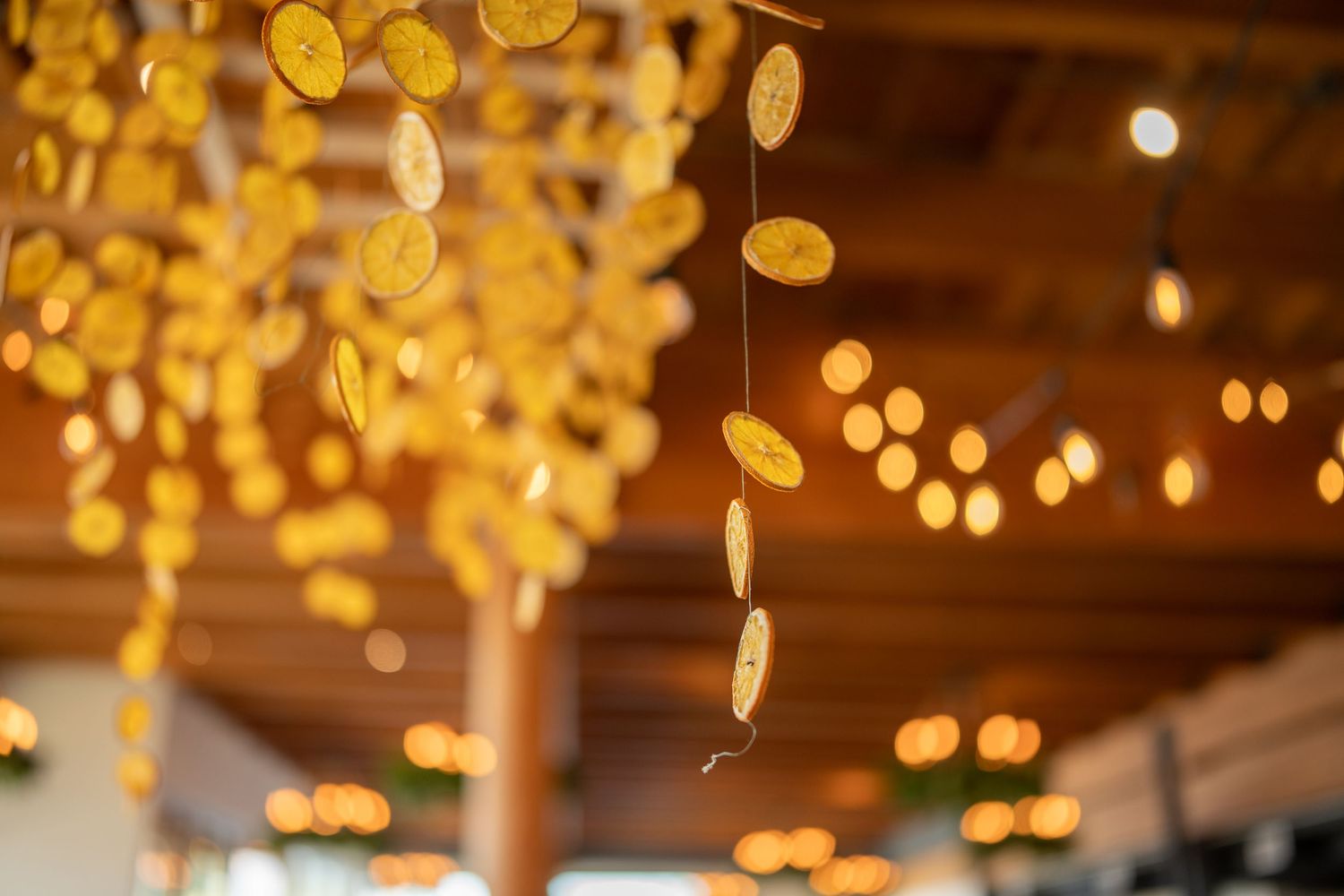 Warm golden bokeh lights create a magical ceiling decoration at a wedding reception.