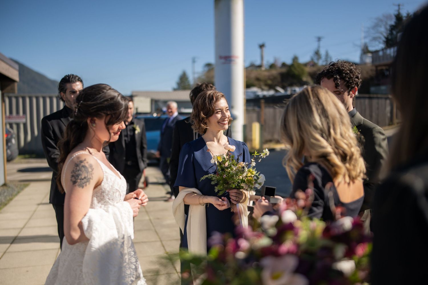 Outdoor waterfront venue decorated with floral arrangements.