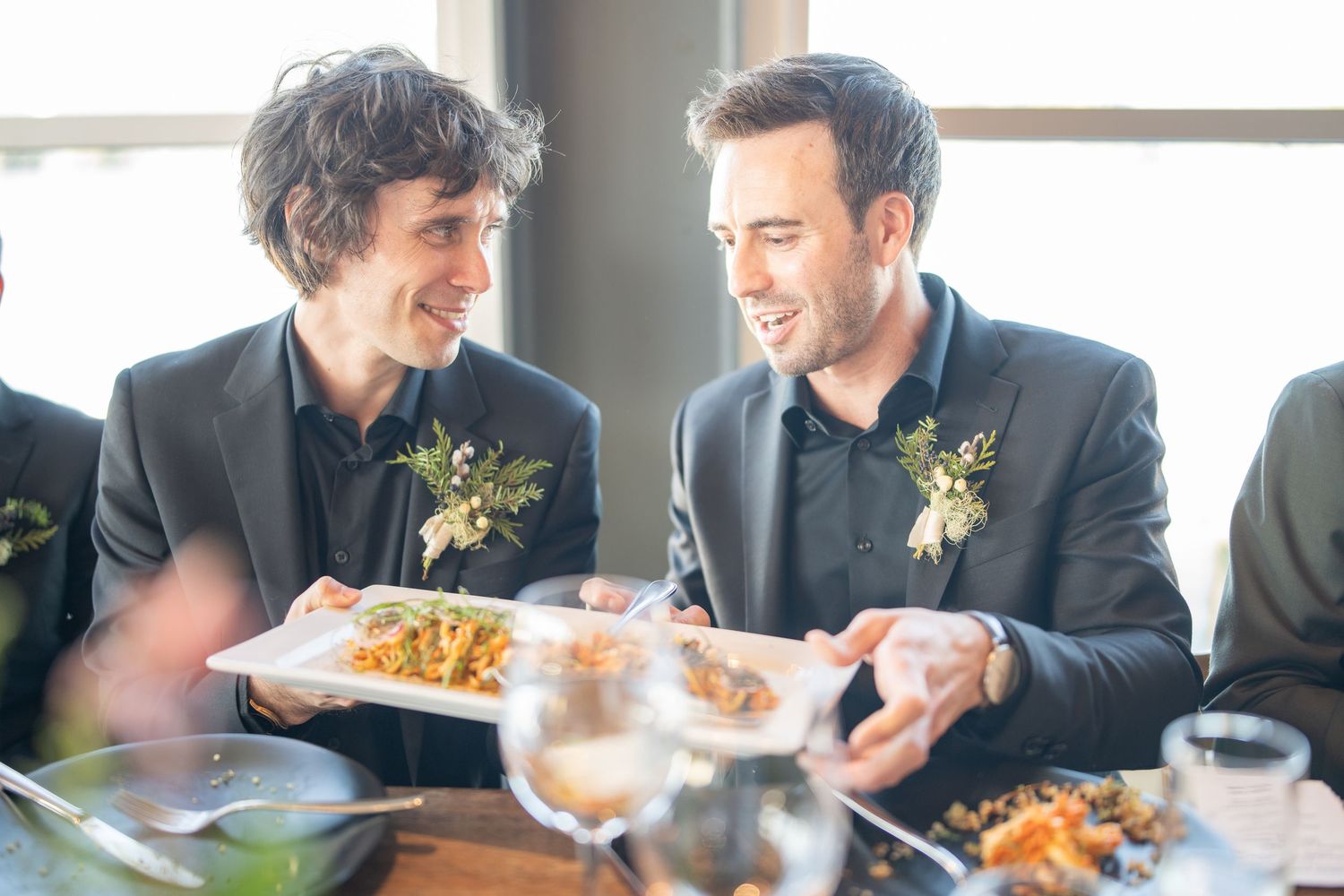Two guests share a joyful moment while dining at an elegant restaurant table.