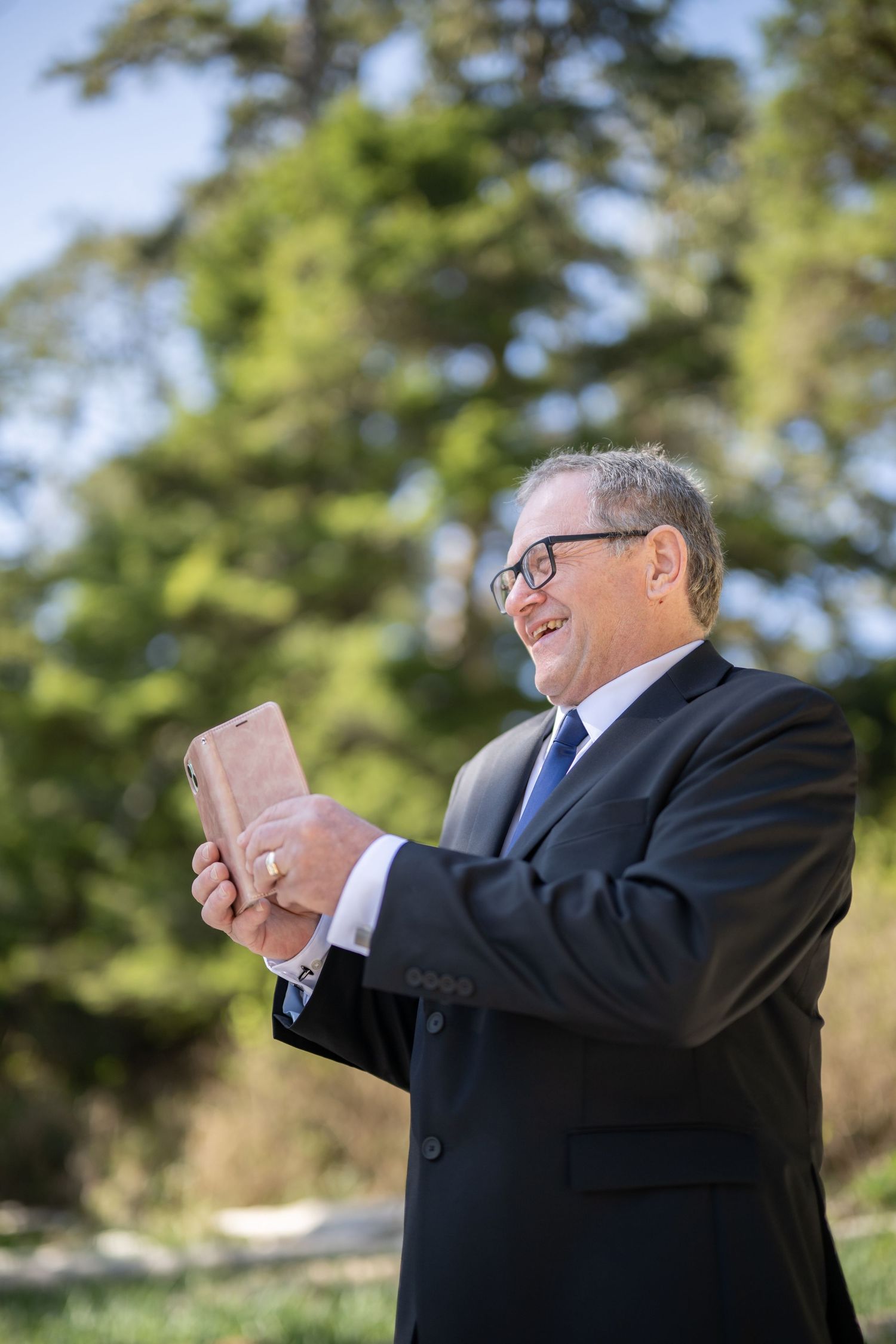 Person in formal attire holding up papers during an outdoor ceremony.