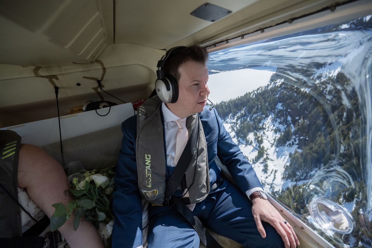 Helicopter passengers seated in cabin during scenic mountain flight.
