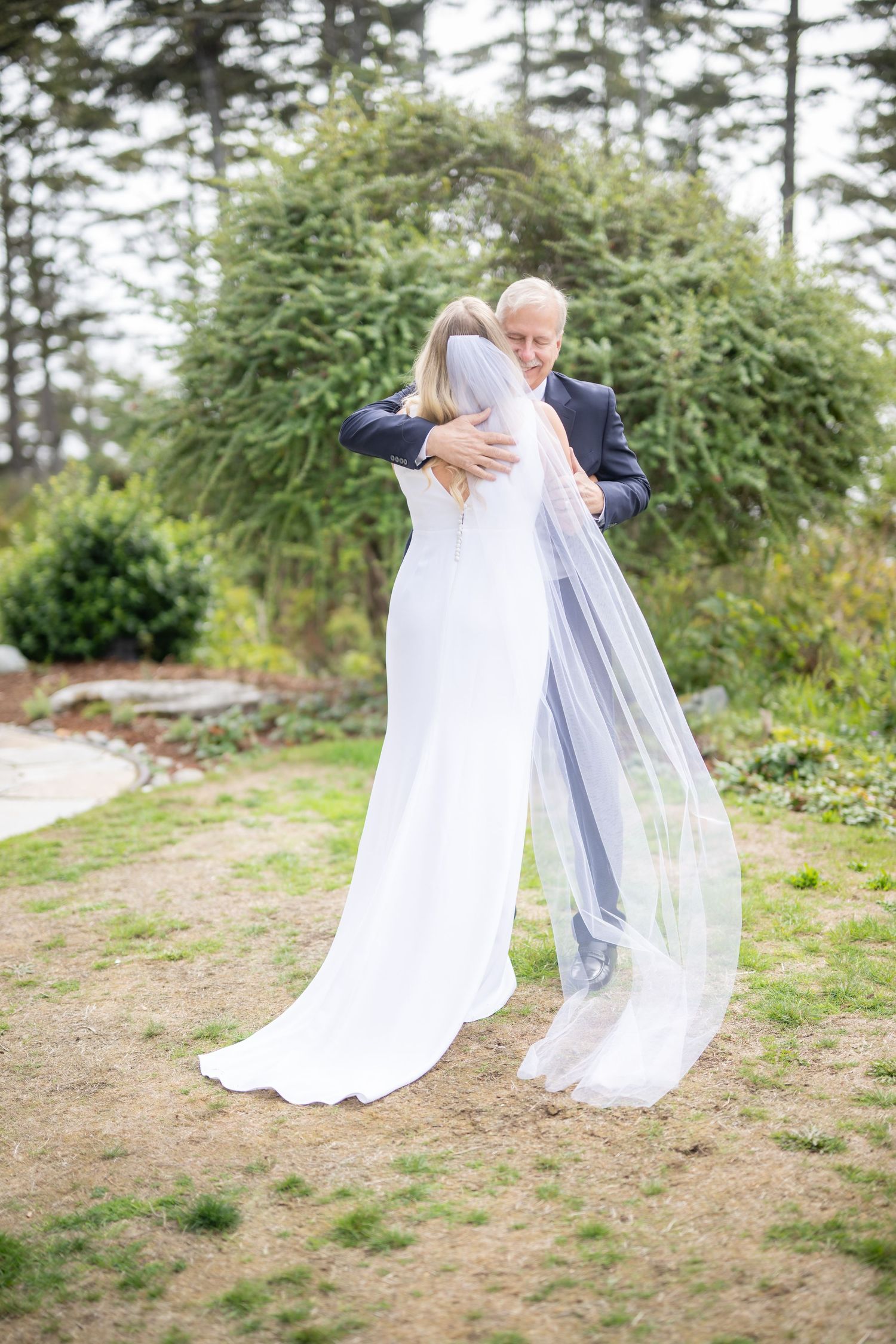 Emotional first look reaction between bride and groom in outdoor garden setting.
