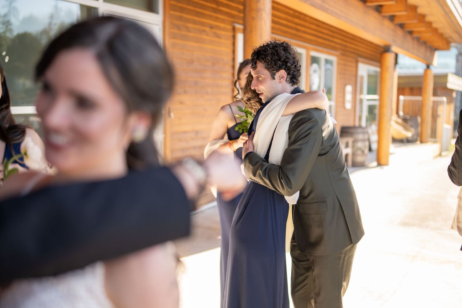Wedding party gathering in a covered outdoor venue with natural lighting.