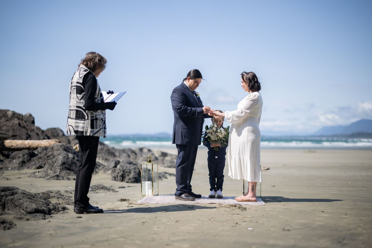 A beachside wedding ceremony with decorative lanterns and natural driftwood elements.