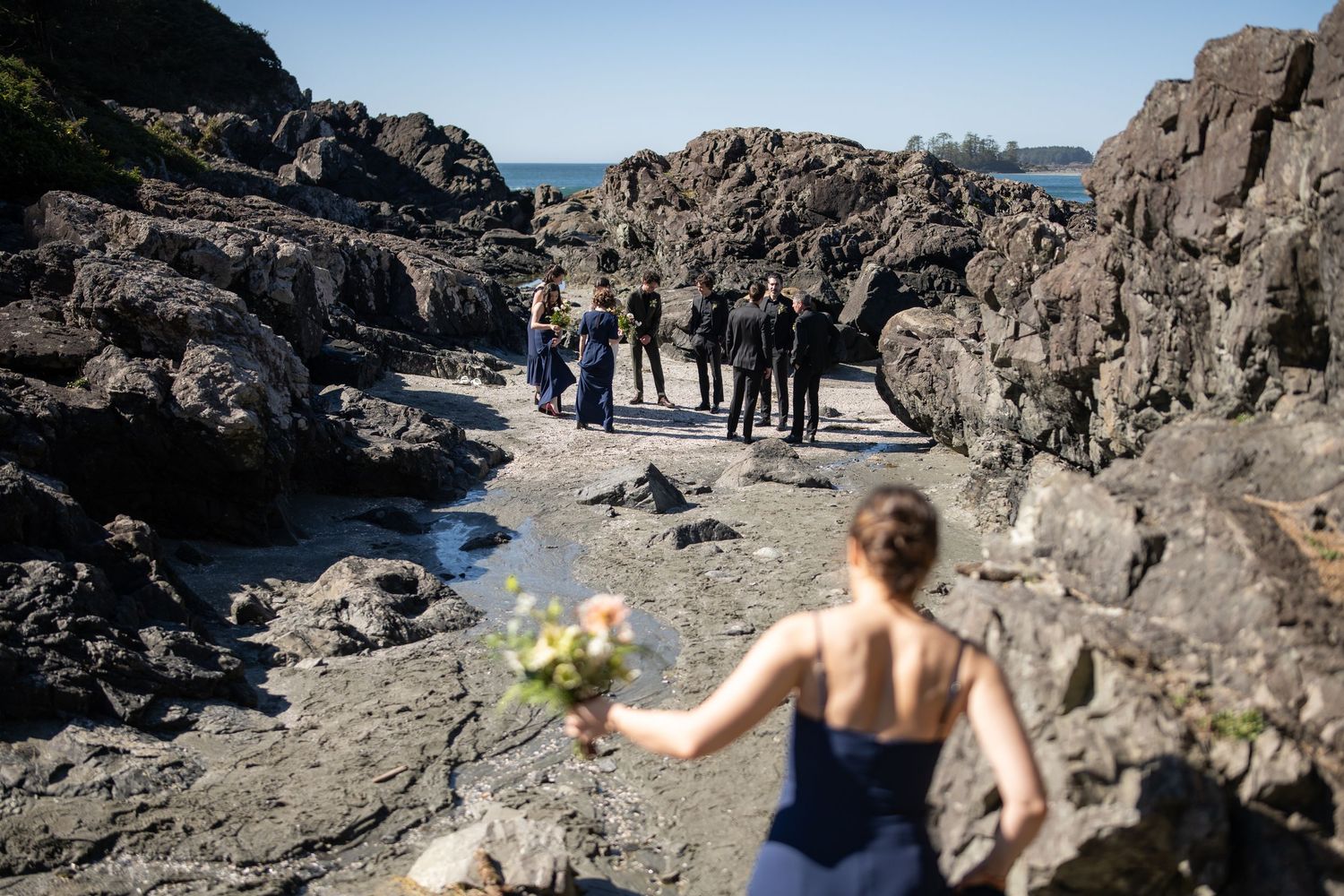 Scenic wedding photography session along rocky coastline with ocean views.