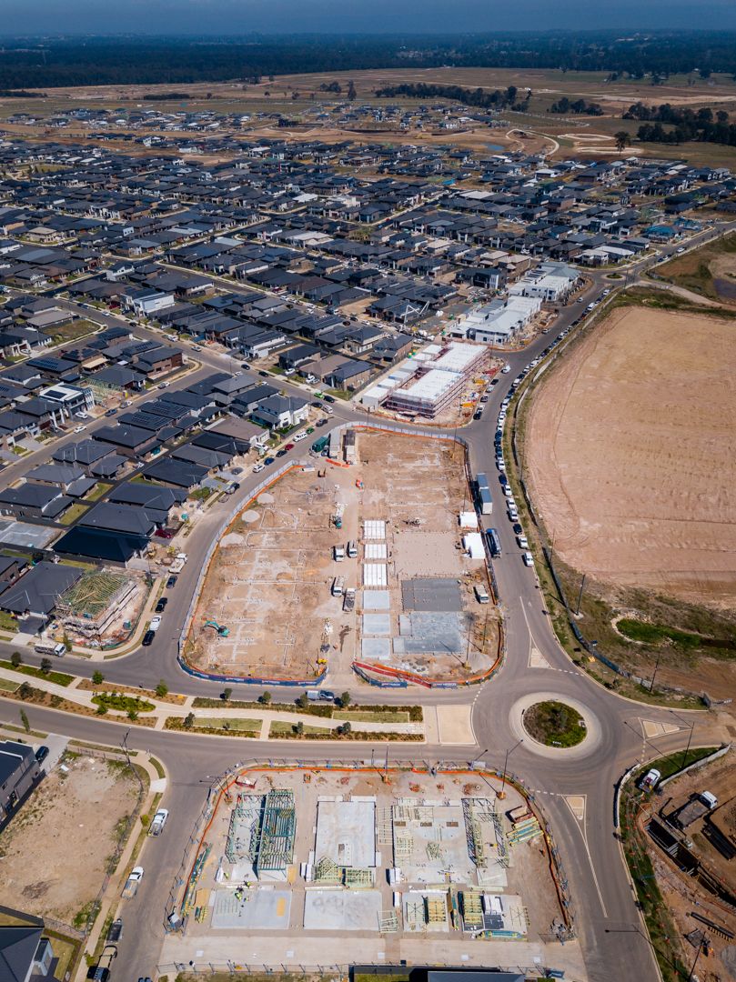Aerial view of a new suburban housing estate with roads, cleared building lots and homes under construction.