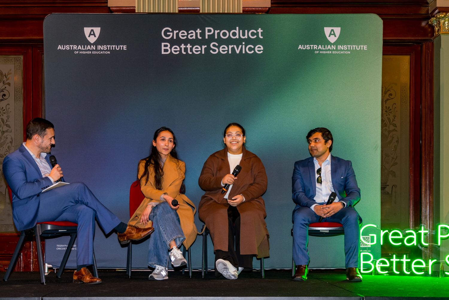 Four panelists sit on stage during a discussion event at the Australian Institute under a Great Product Better Service banner.