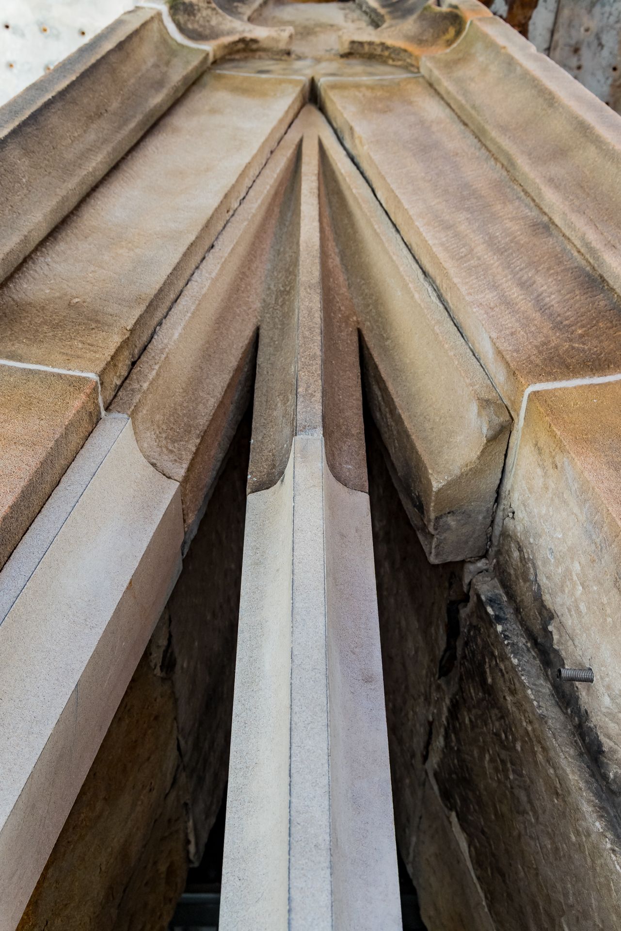 Close-up of converging stone ribs and carved surfaces forming a pointed Gothic vault detail with a central ridge.