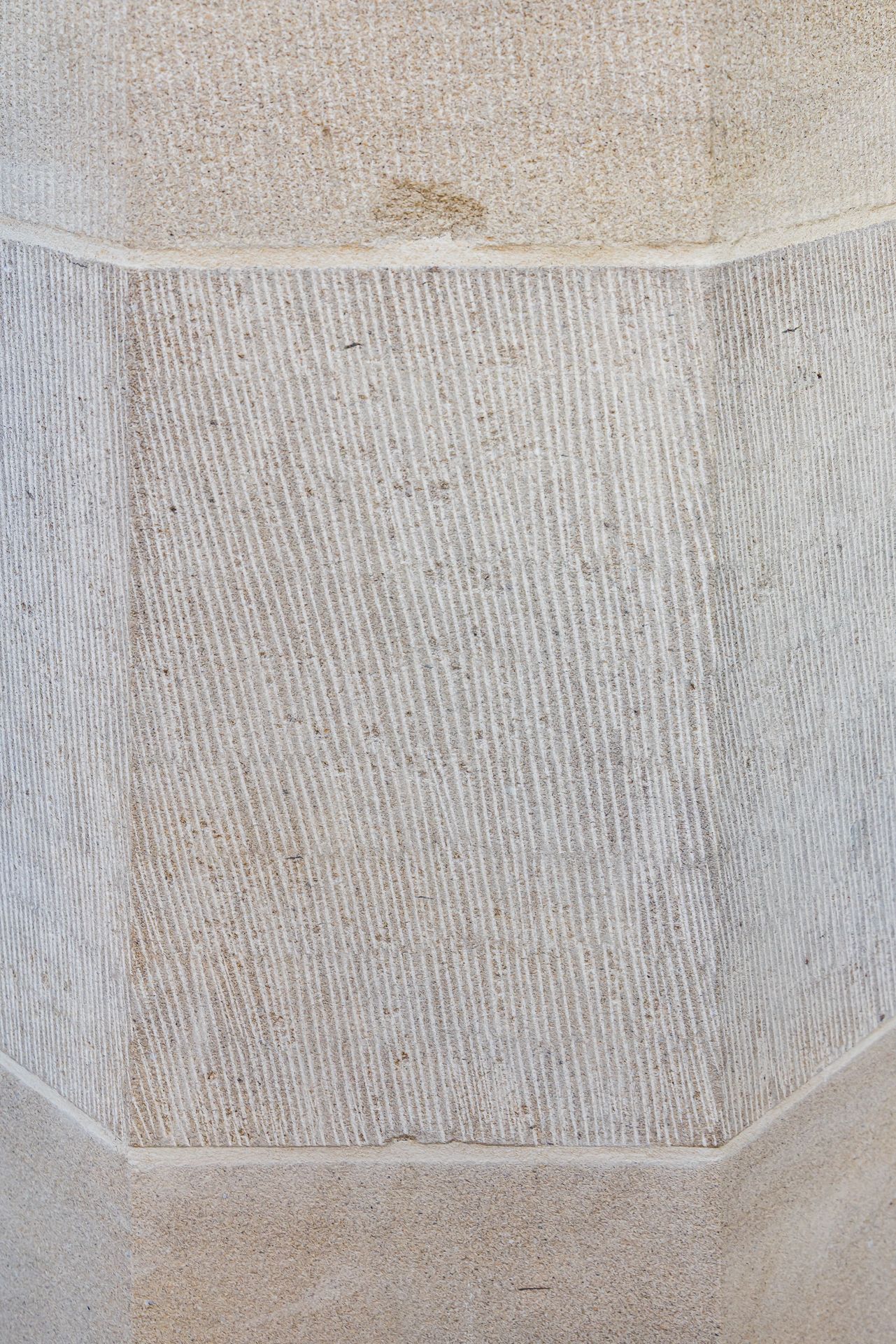 Detailed sandstone wall panel with fine vertical chisel marks and smooth beveled borders.