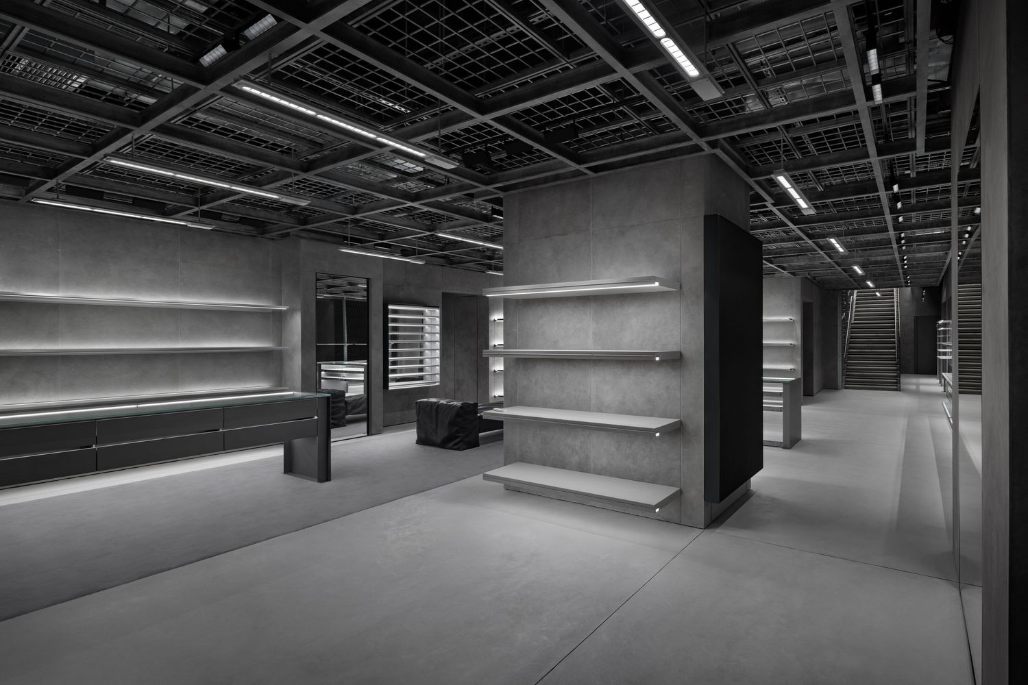 Minimalist concrete-walled store interior with floating metal shelves, exposed ceiling grid, and moody dramatic lighting.
