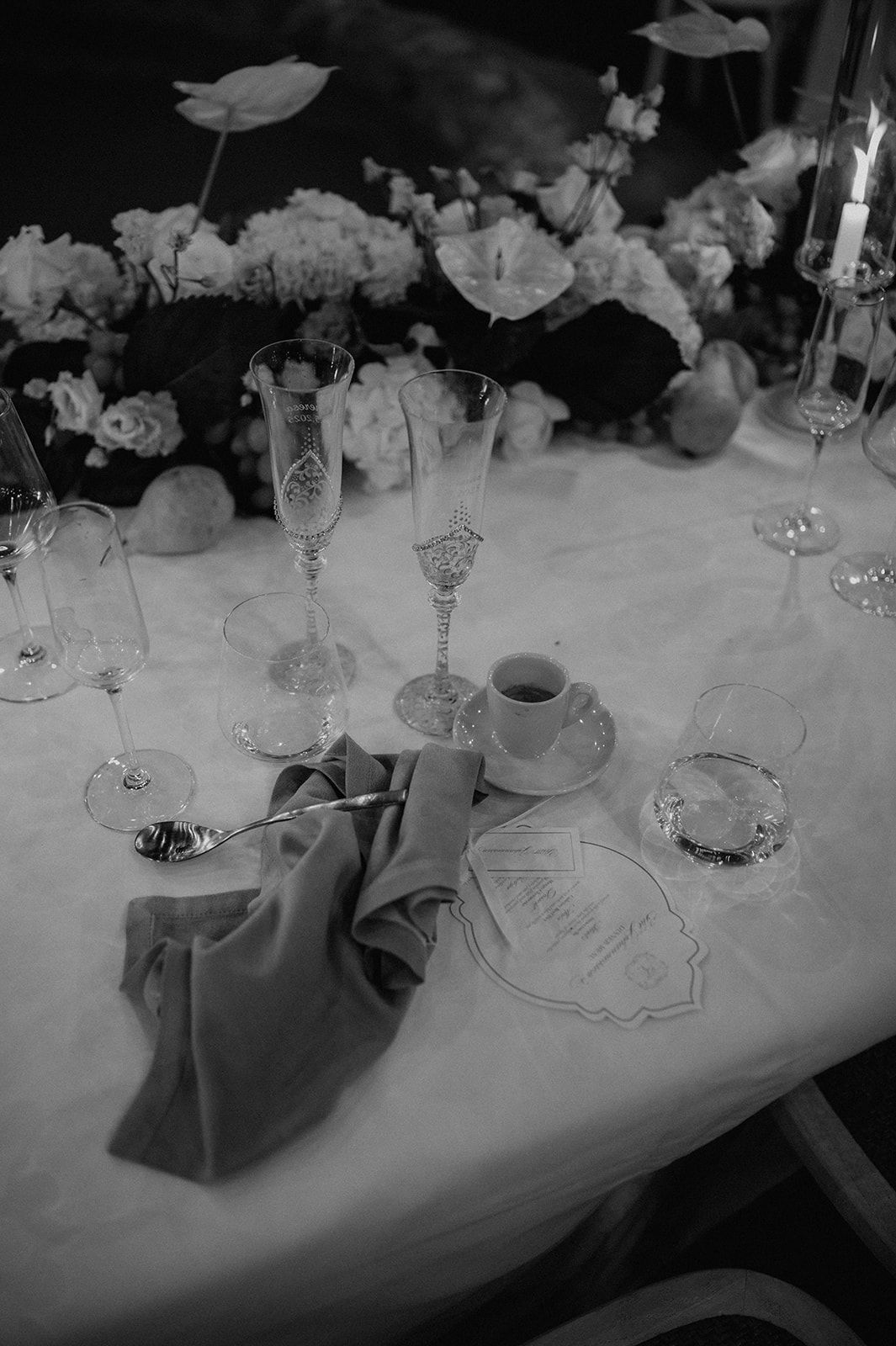 Black and white wedding table setting with champagne flutes, floral centerpiece, and elegant place settings.