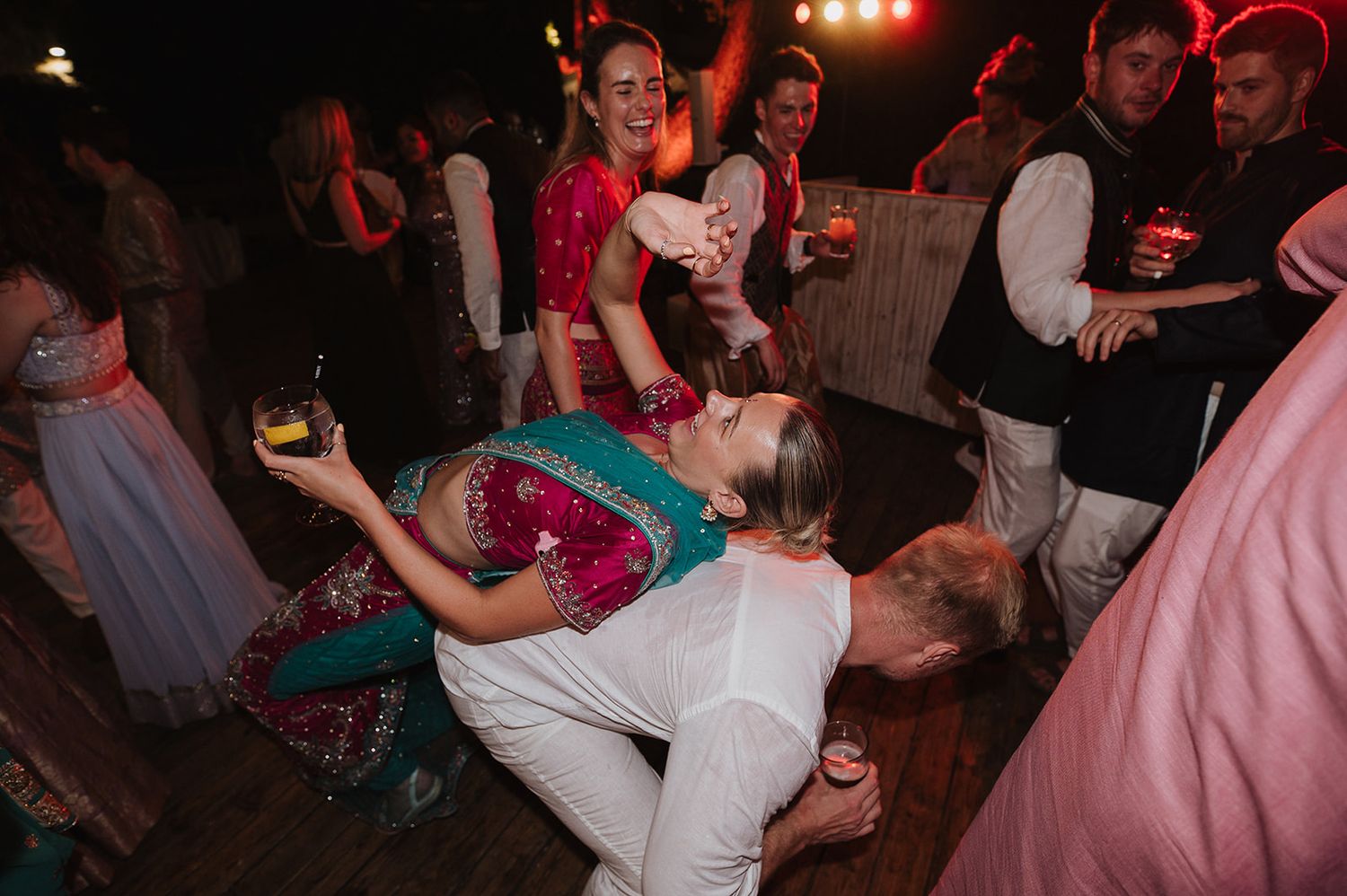Energetic wedding guests dancing and dipping on the dance floor at a vibrant Indian wedding party.
