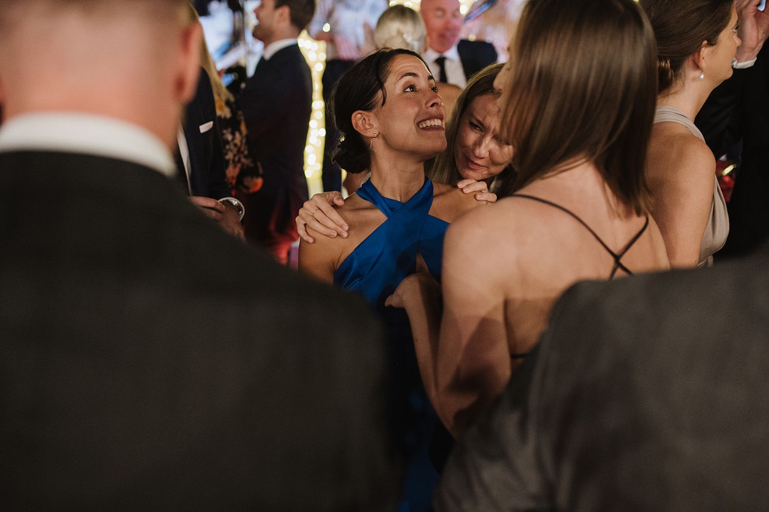 Emotional wedding guests embrace warmly during the celebration reception.