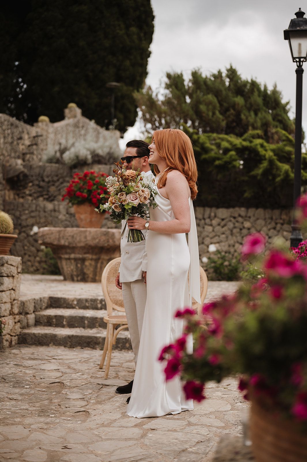 Bride and groom share tender first look moment surrounded by colorful flowers at garden wedding.