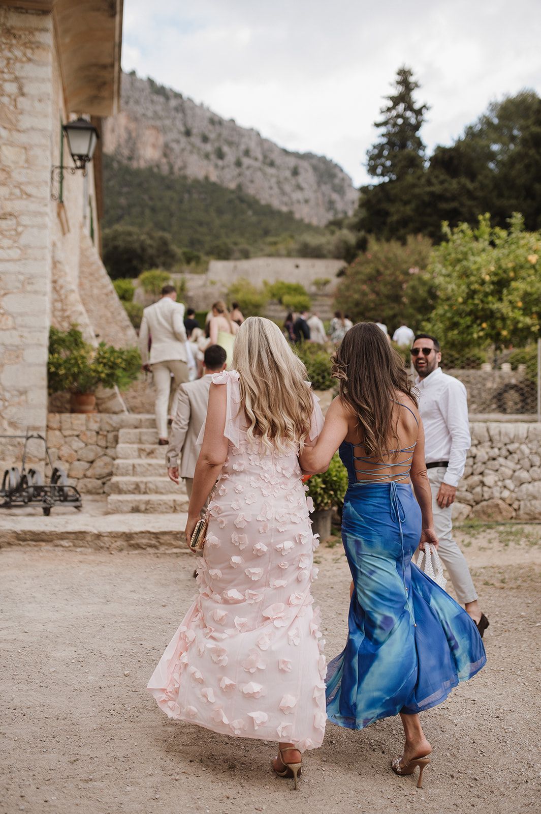 Wedding guests walking toward an outdoor ceremony at a scenic mountain stone venue.