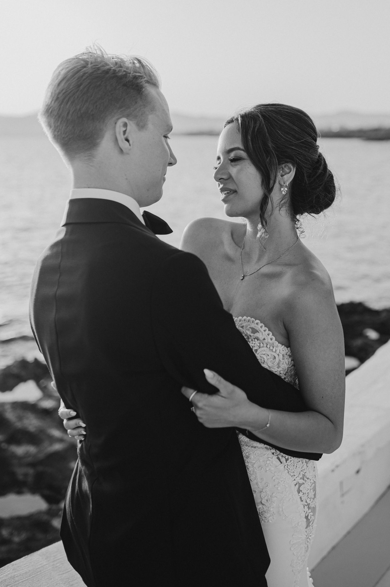 Bride and groom share an intimate black and white moment by the ocean after their ceremony.