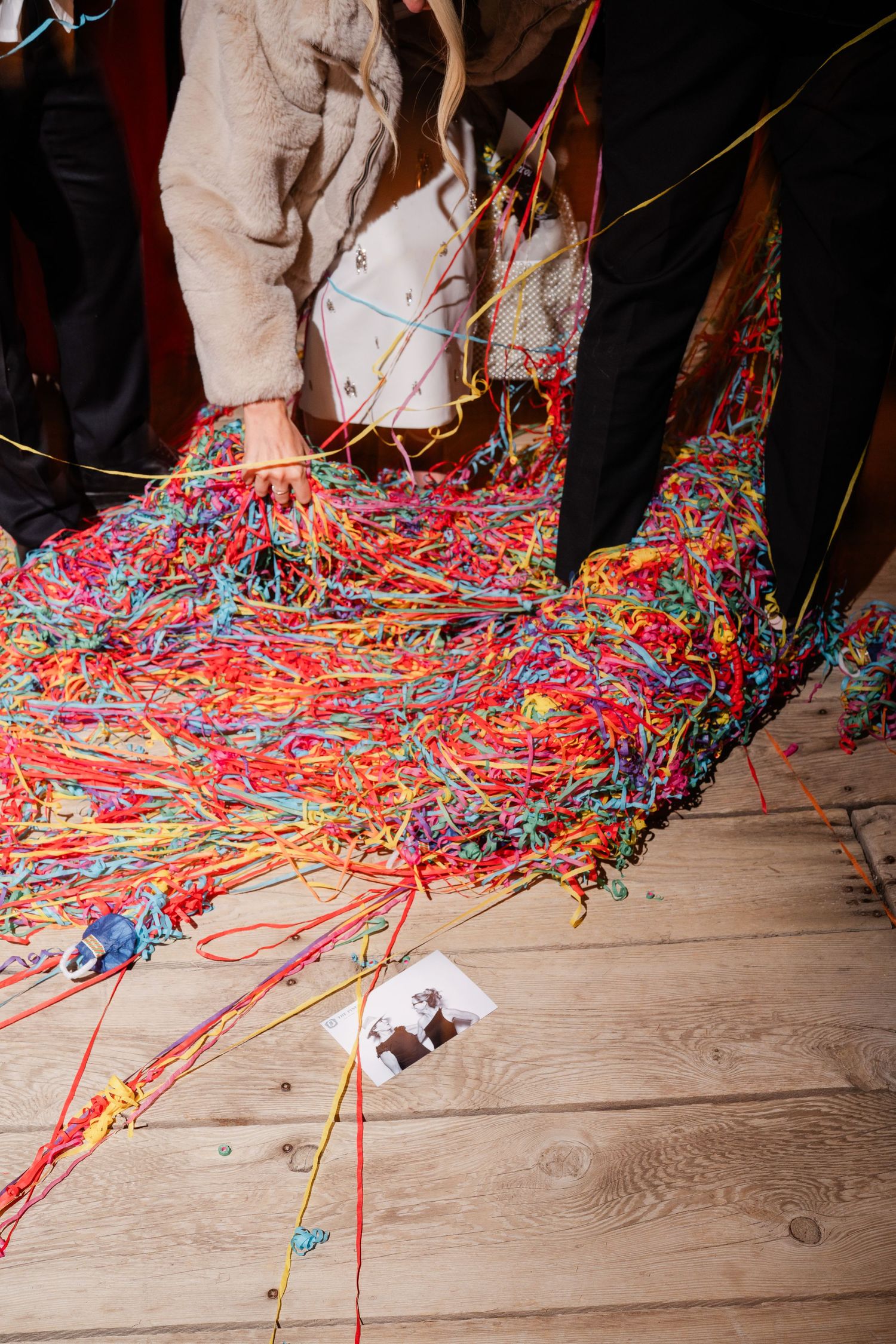 Colorful streamers covering wooden floor at end of wedding celebration.