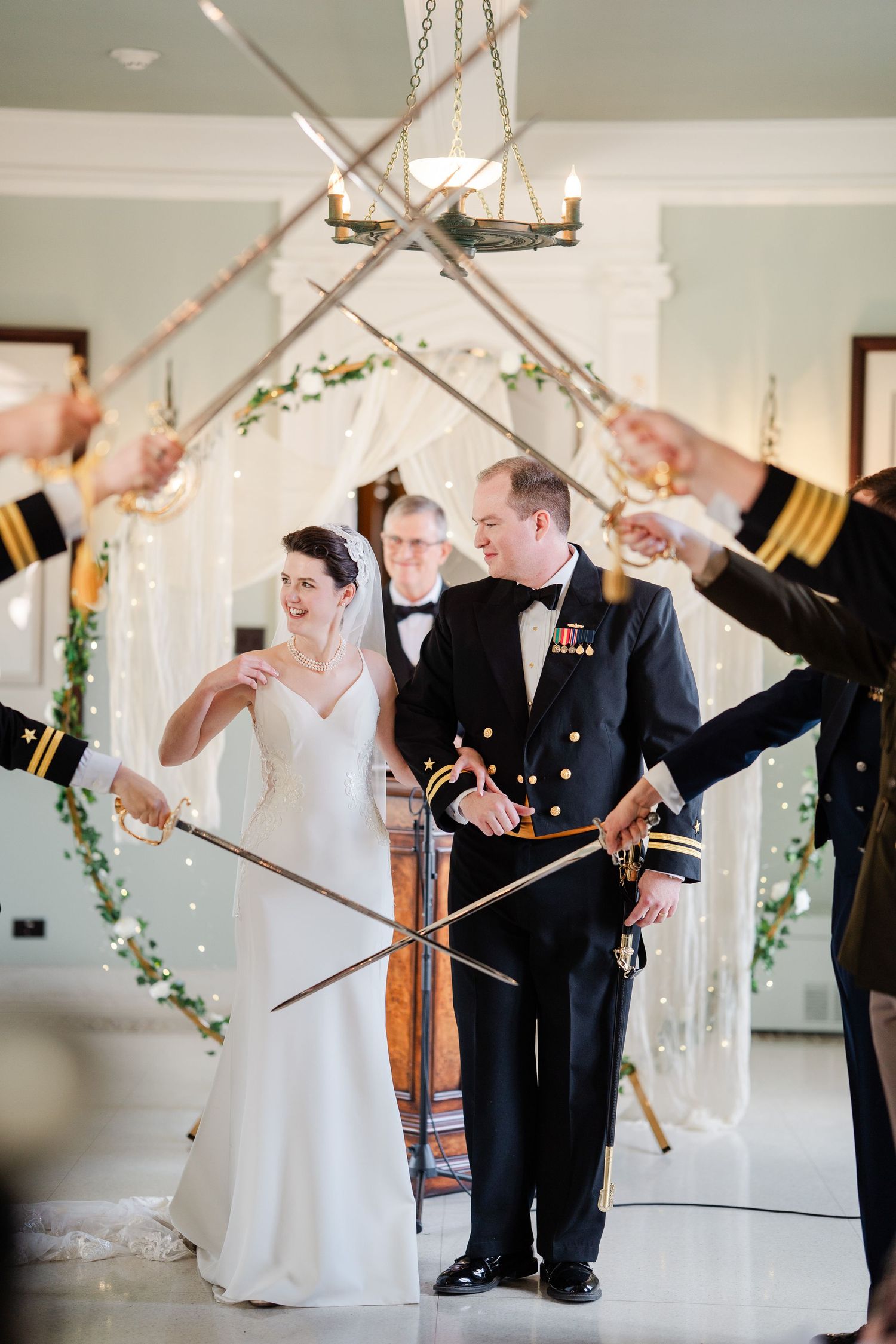 Military wedding couple walking through a sword arch ceremony with uniformed officers.