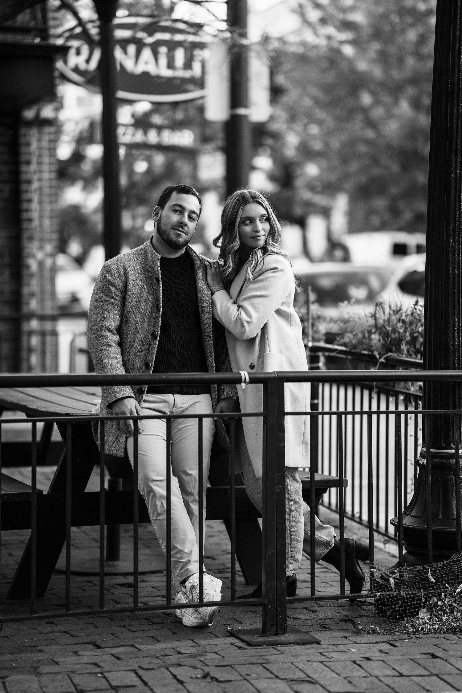 Black and white photo of a stylish couple posing together outside Ranalli's Pizza Bar in Chicago.