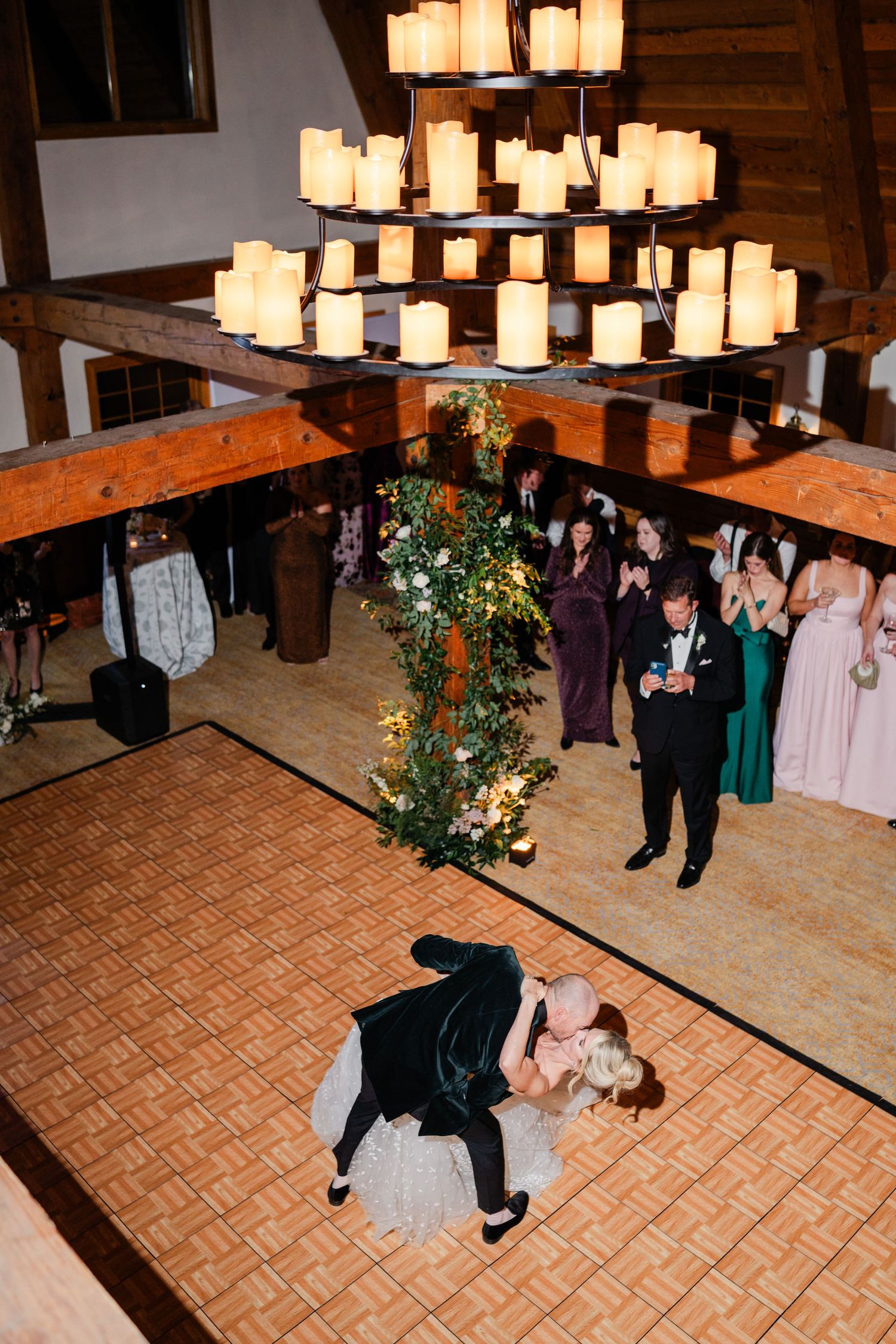 Aerial view of bride and groom first dance under candle chandelier.
