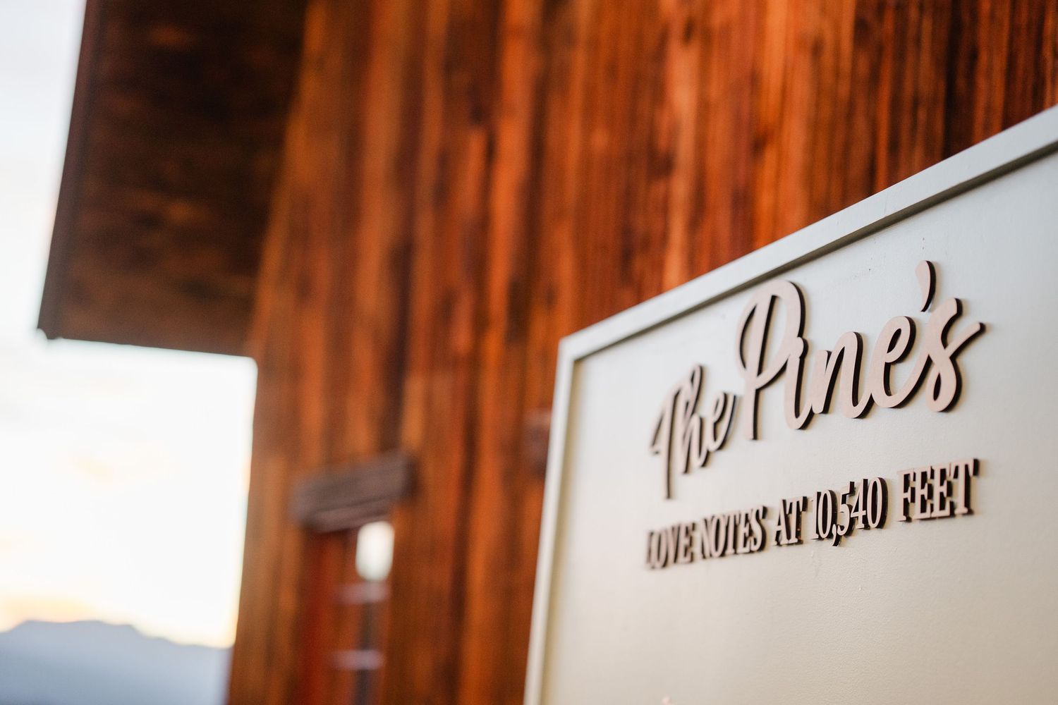 The Pine's venue sign on rustic wood wall at 10,040 feet elevation.