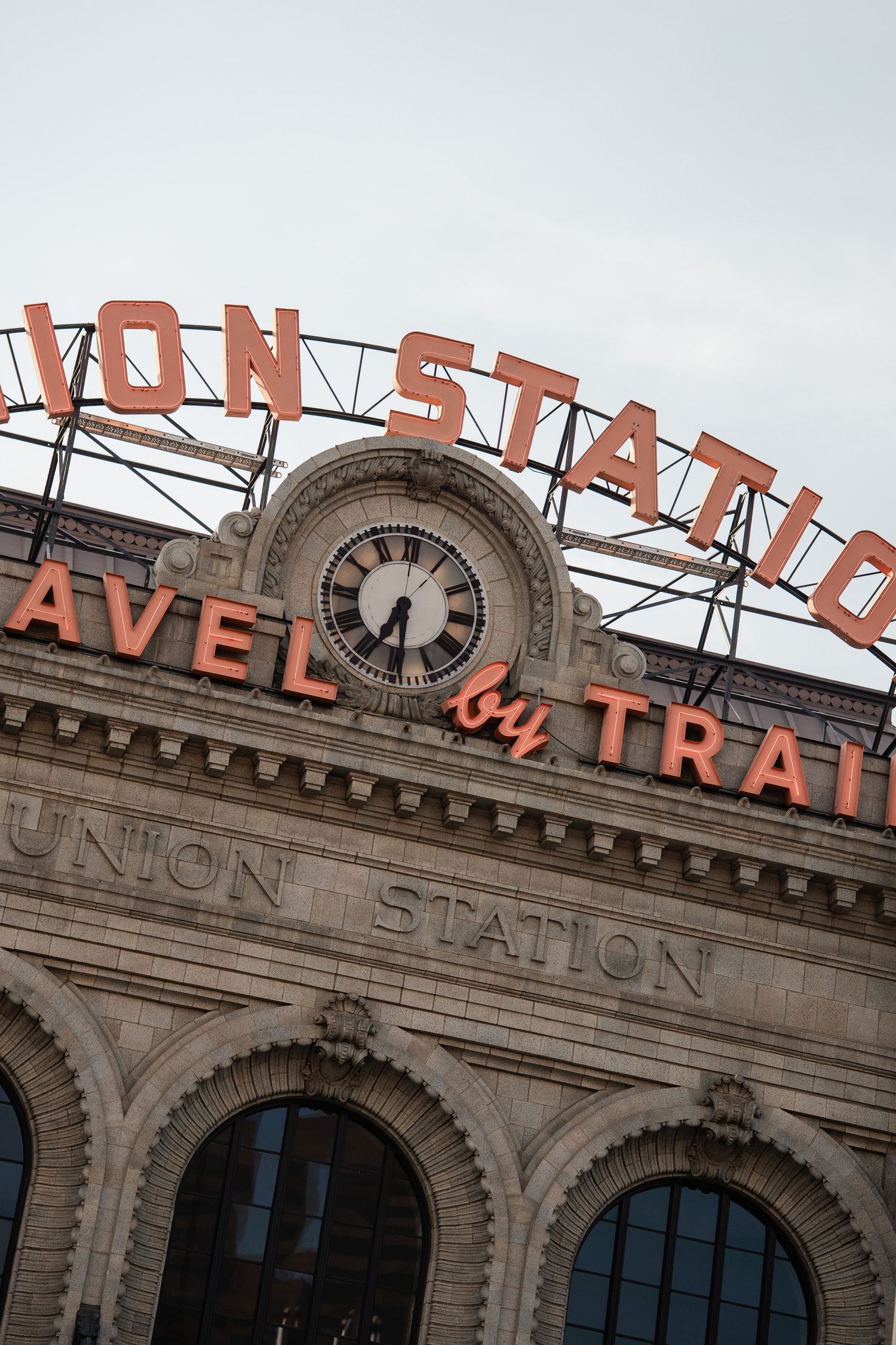 Historic Union Station building facade with iconic neon sign and clock in Denver, Colorado.