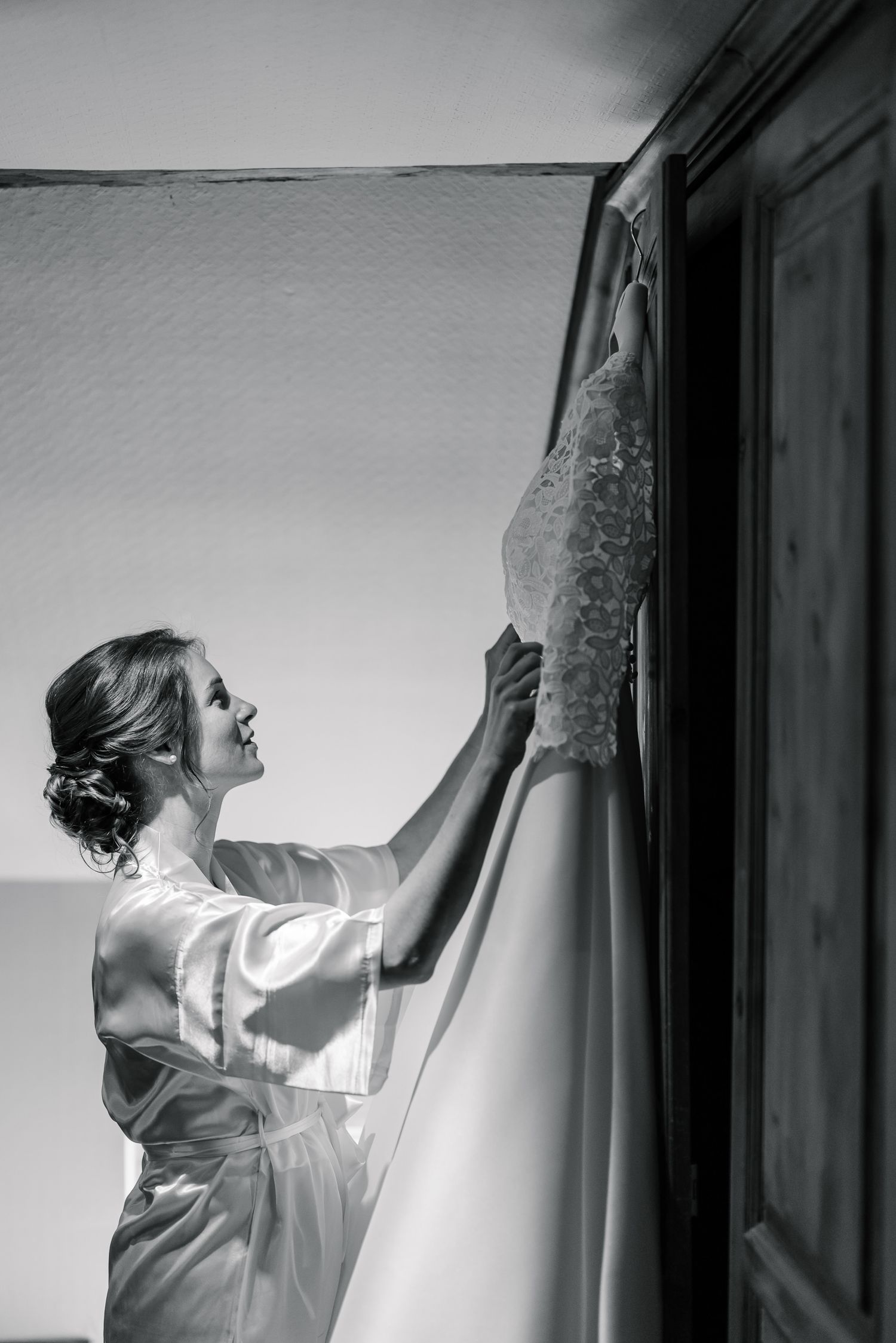 A series of black and white photos showing a person adjusting curtains in a window, creating a dramatic lighting effect.