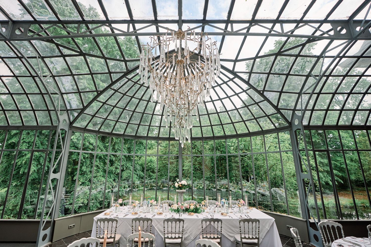 A series of architectural photos showing a glass conservatory ceiling with ornate metalwork and crystal chandeliers.