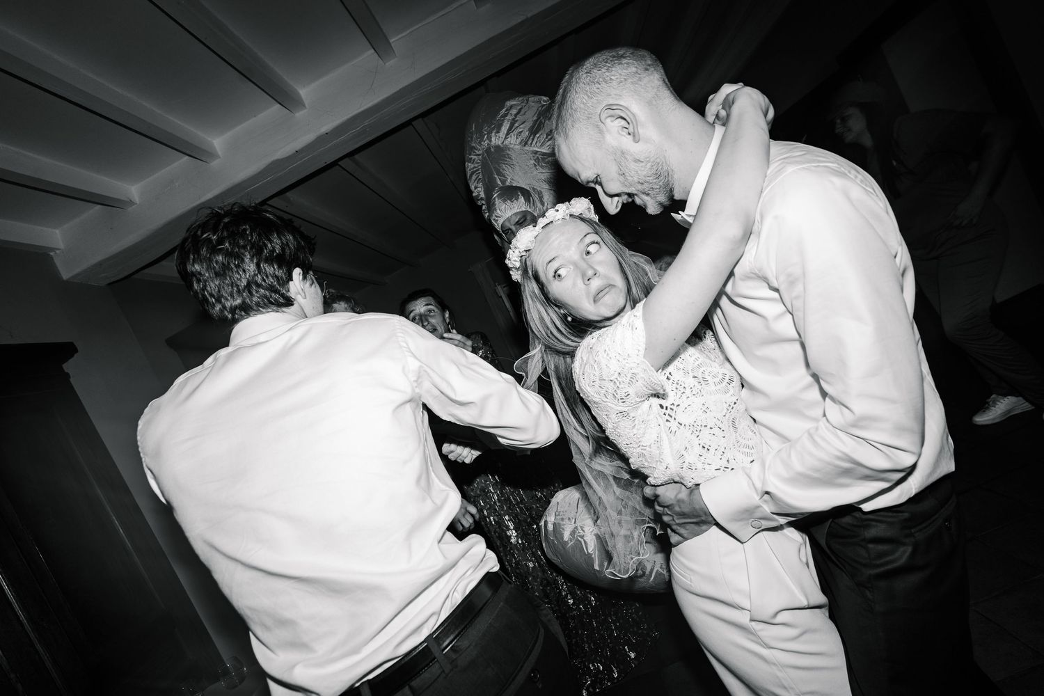 A sequence of black and white photographs showing dancers performing close partner dance moves in a dimly lit setting.