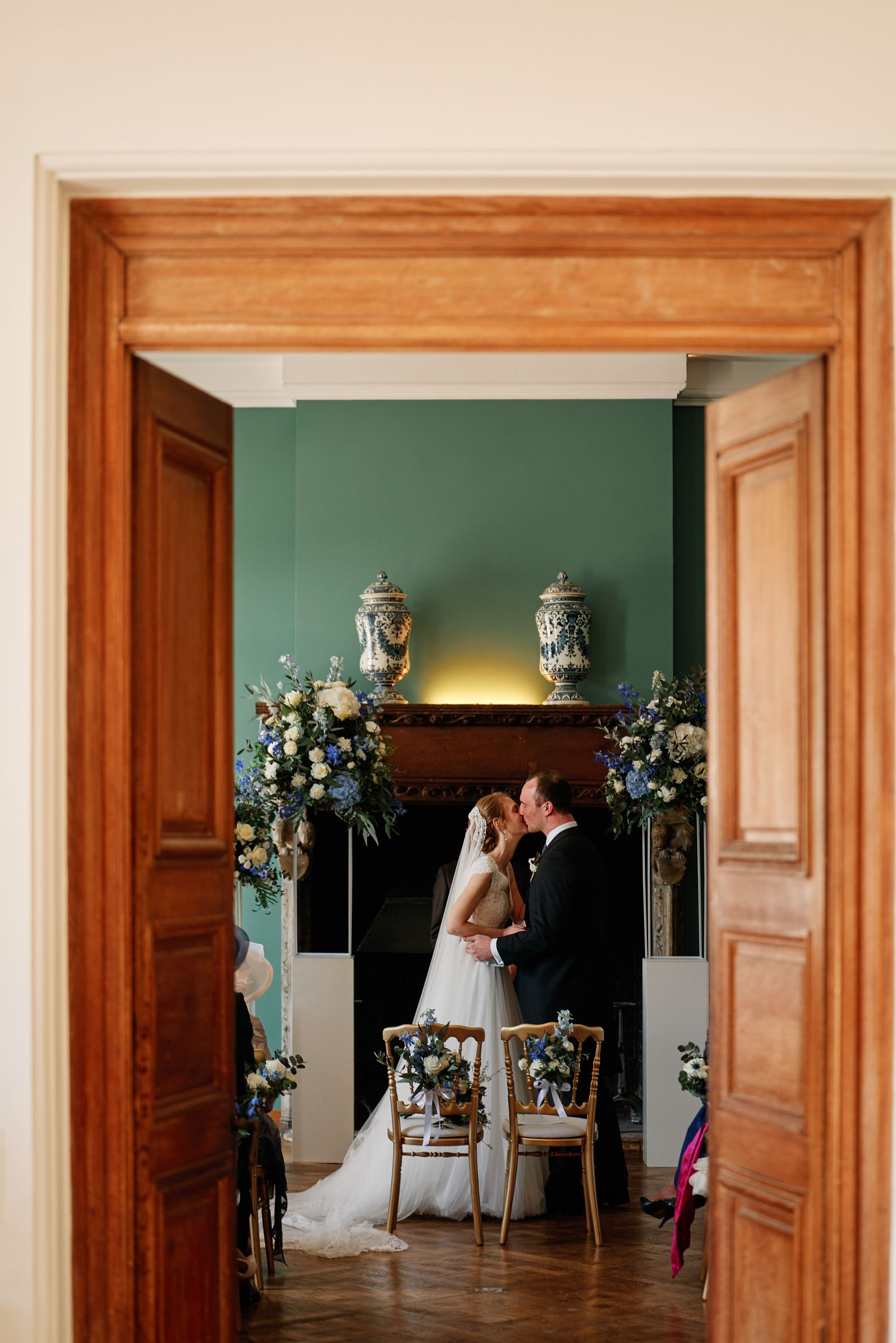A series of wooden doorway frames showing a wedding scene with floral decor and turquoise walls in the background.