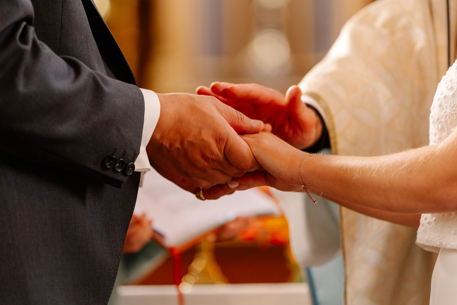 Close up of hands exchanging items during formal ceremony.