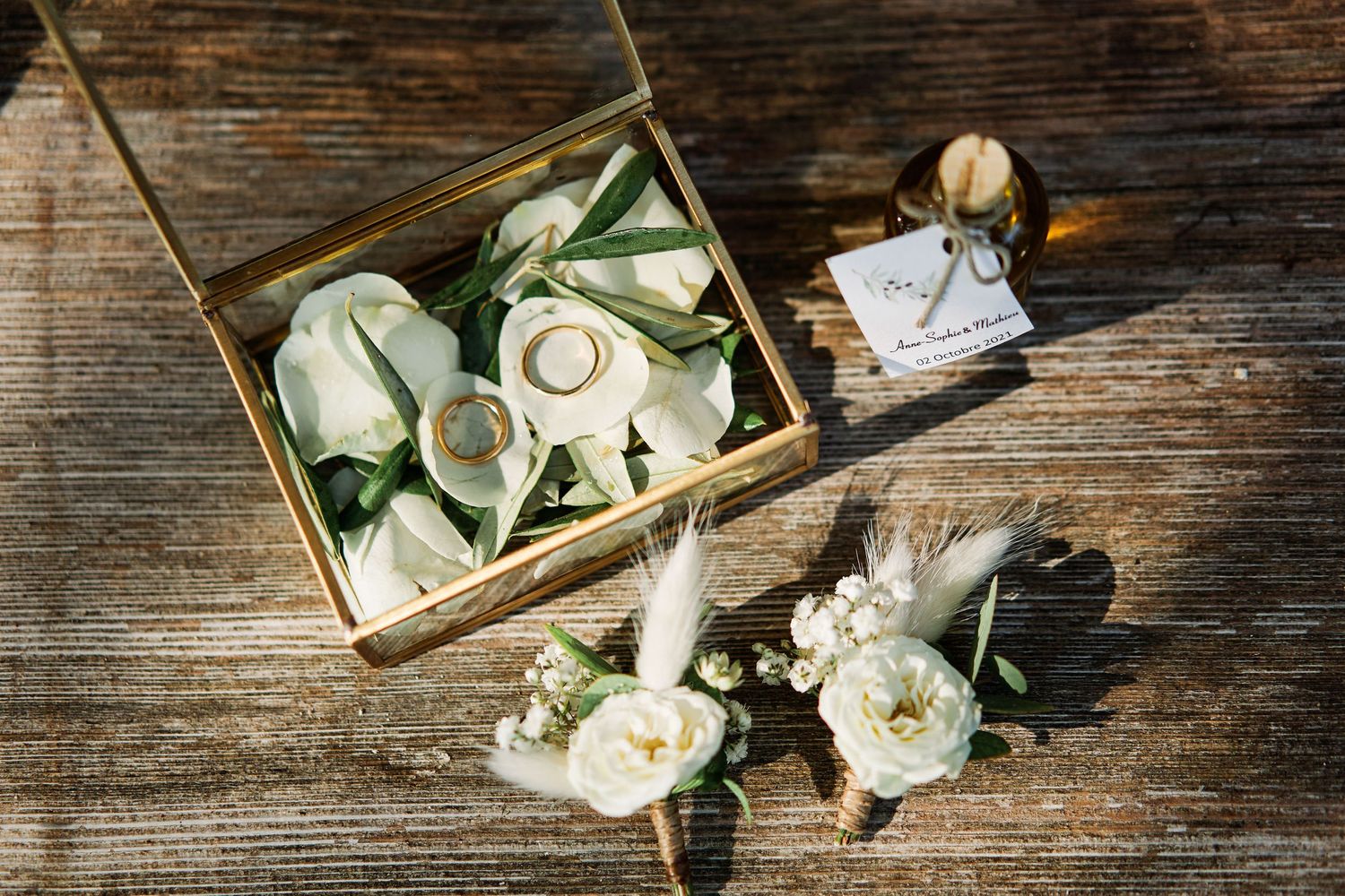 Vintage compass and dried white roses arranged on rustic wooden surface with antique map details.