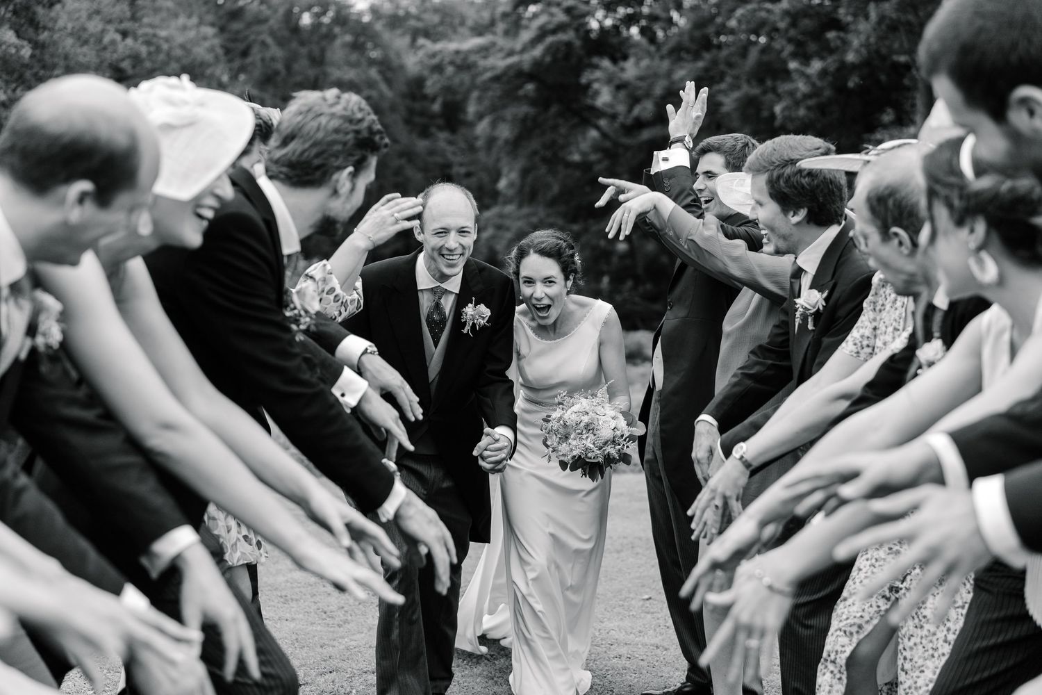 A series of black and white photos showing wedding guests dancing and celebrating at a reception.