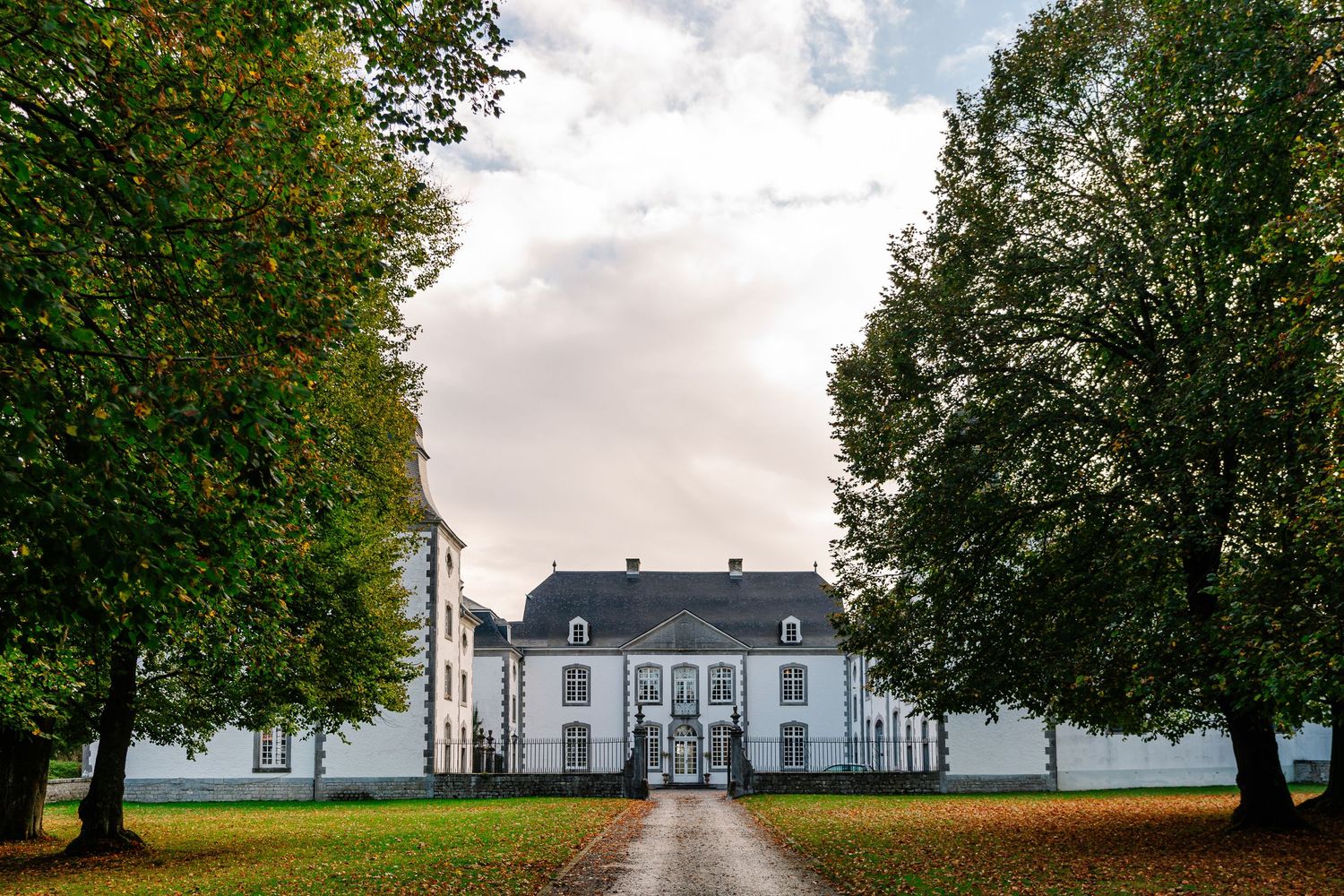 A panoramic view shows a white colonial mansion with green trees and cloudy skies stretching across multiple frames.