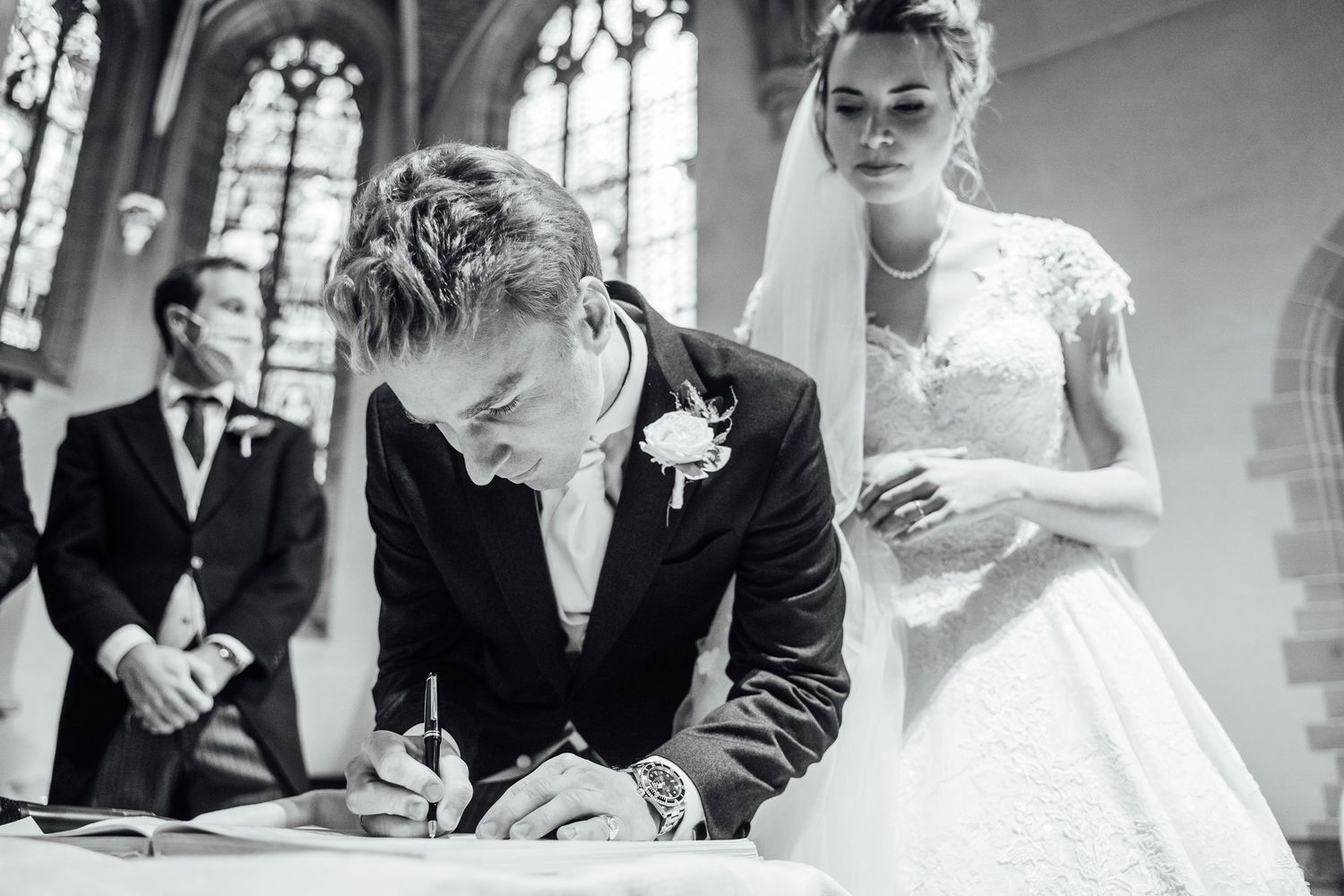A black and white photo collage of wedding moments showing couples signing documents and exchanging rings at a church ceremony.