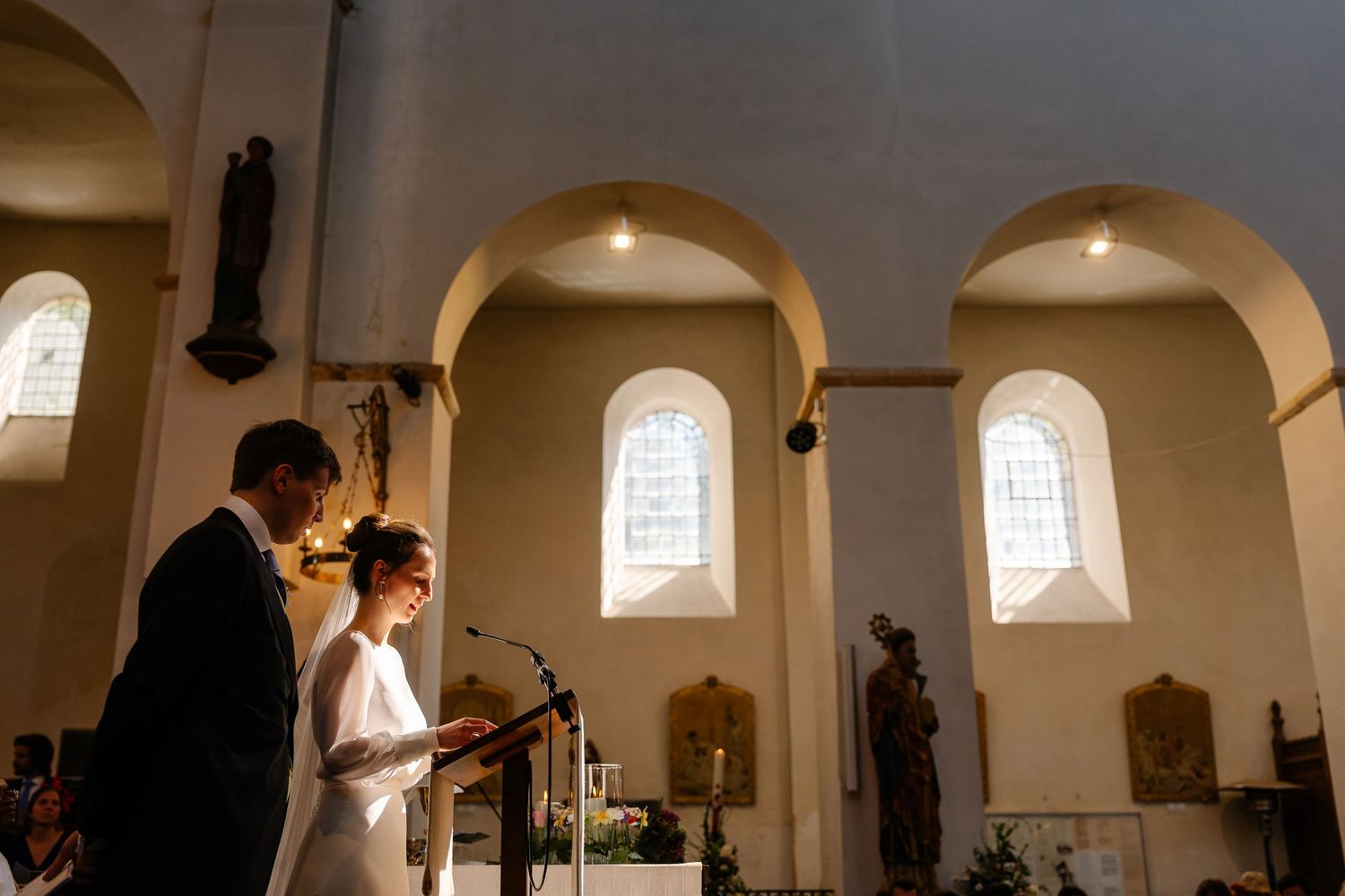 A series of black and white photos showing people in formal attire inside an elegant church or chapel interior.