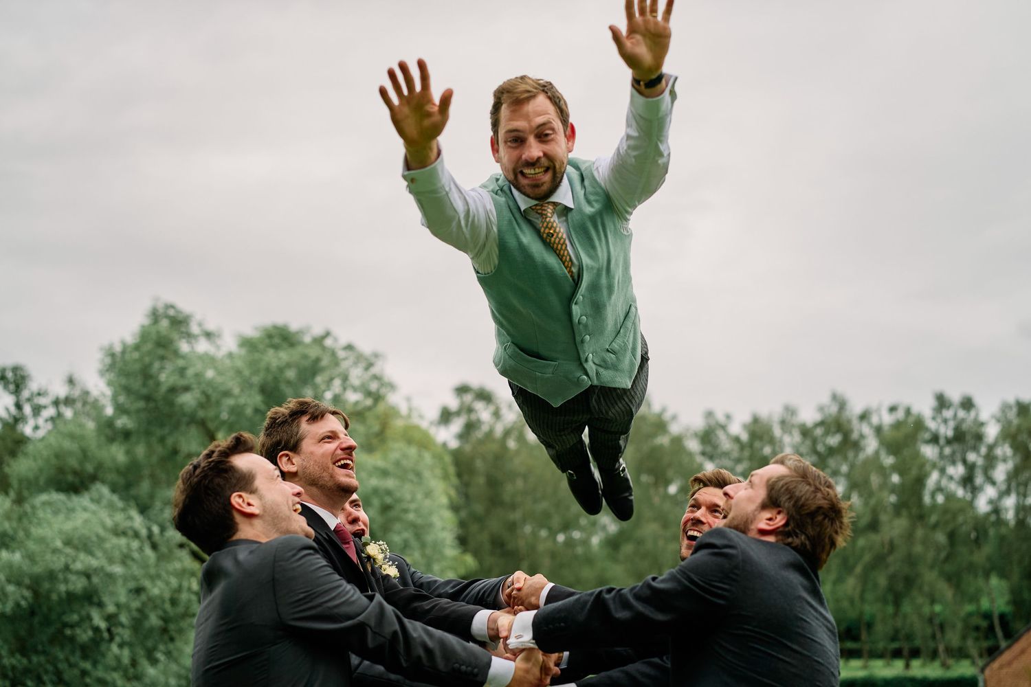A sequence of photos shows people jumping in the air with joyful expressions in a green outdoor setting.