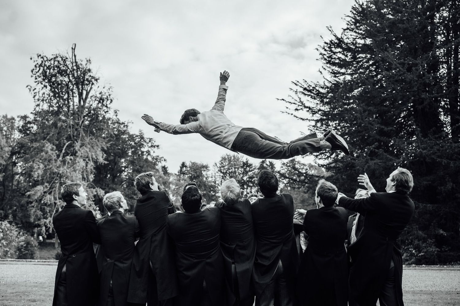 A sequence of black and white photos showing graduates tossing their caps into the air during a celebration.